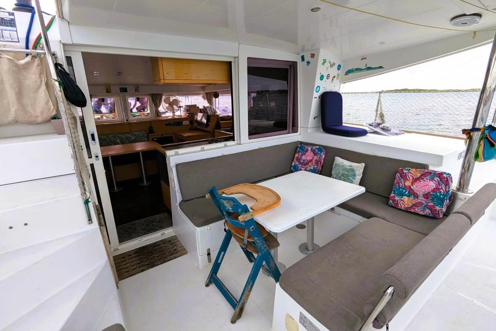 Cozy interior of 2015 Lagoon 400 S2 catamaran with colorful cushions and dining area.
