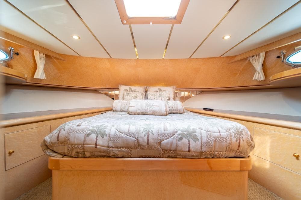 Luxurious bedroom interior of 2005 Ocean Alexander 64 Motoryacht with elegant bedding and wood finishes.