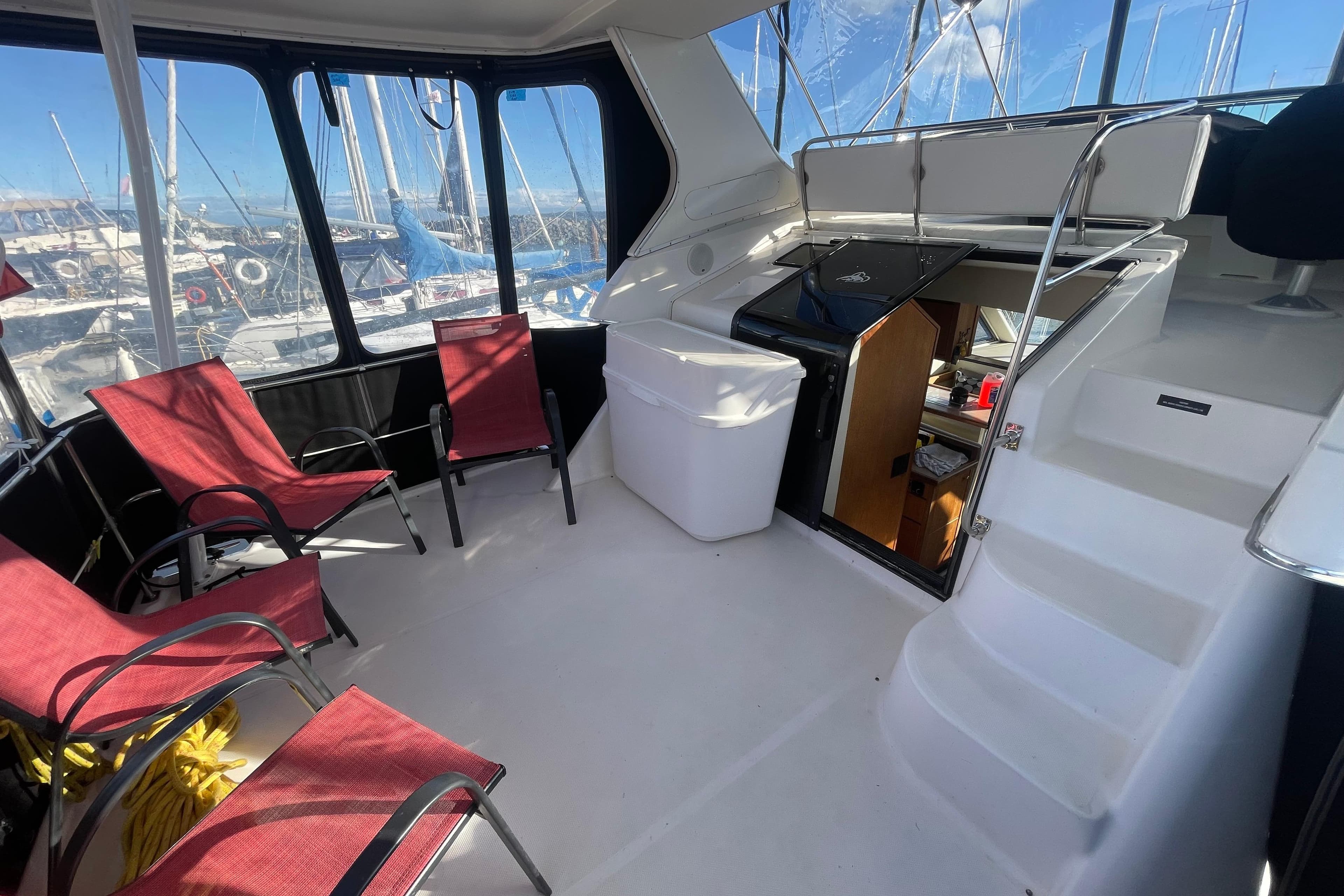 1996 Bayliner 4087 Aft Cabin Motoryacht interior with red chairs and marina view.