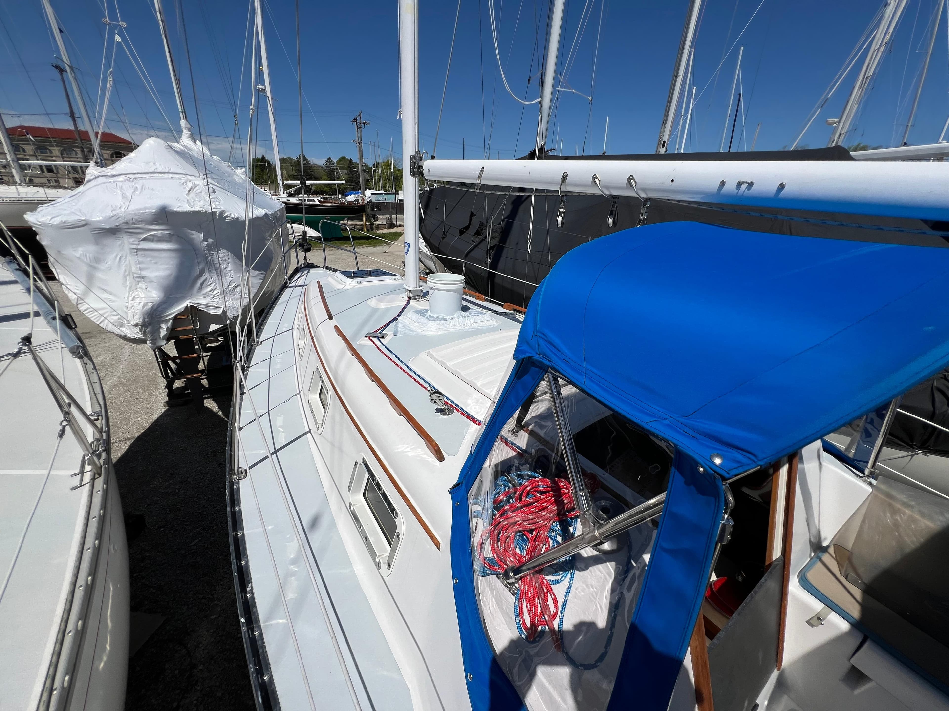 1983 Hunter 27 sailboat with blue canopy docked at marina.