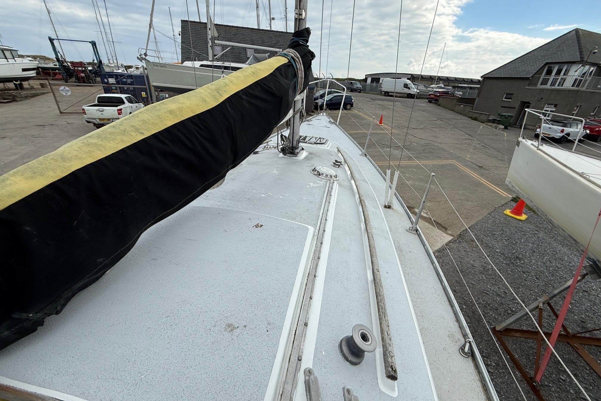 1980 Sadler 25 sailboat on dry dock, showcasing deck and marina surroundings.