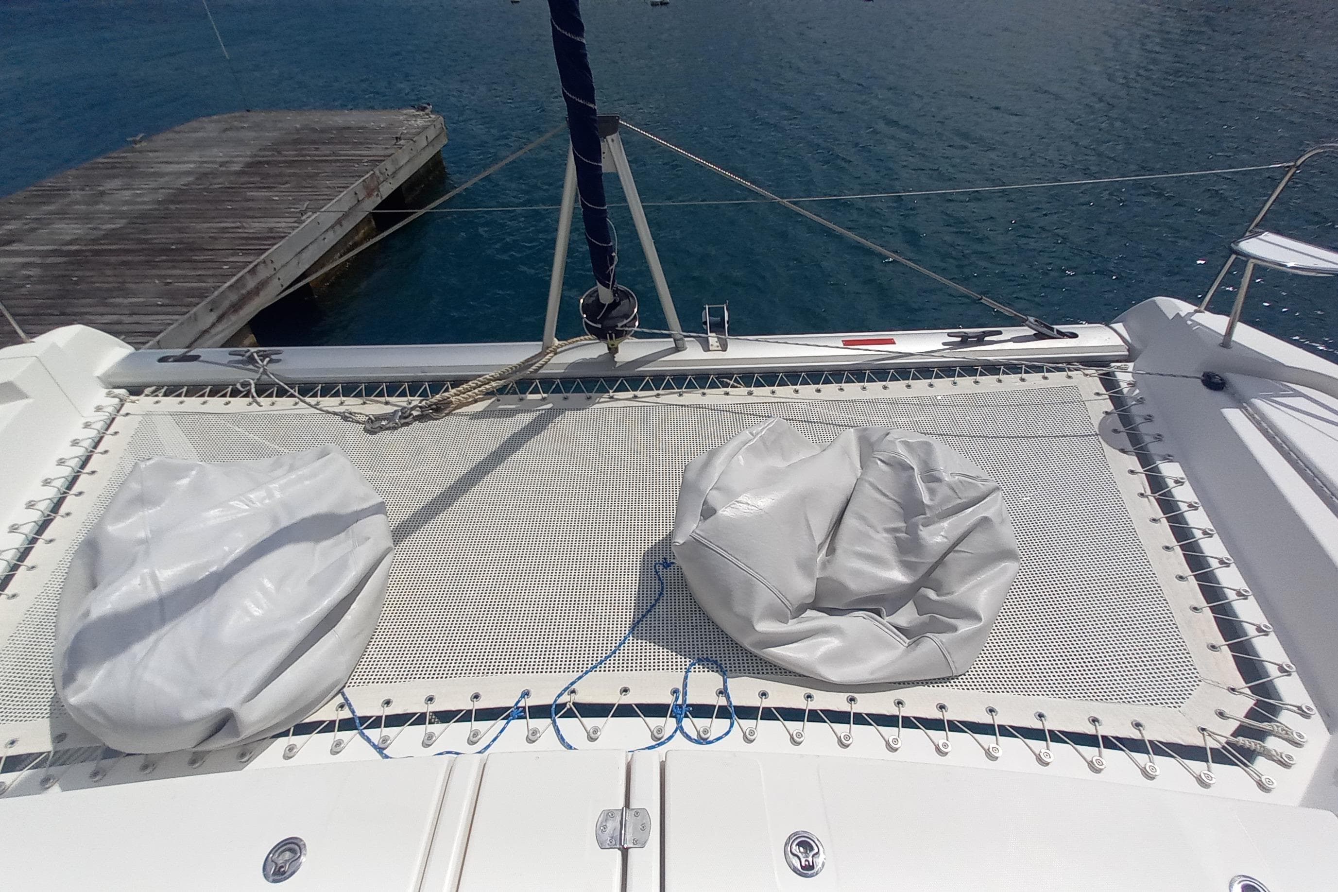 Catamaran Leopard 45 (2019) with netted deck and bean bags, docked by the water.