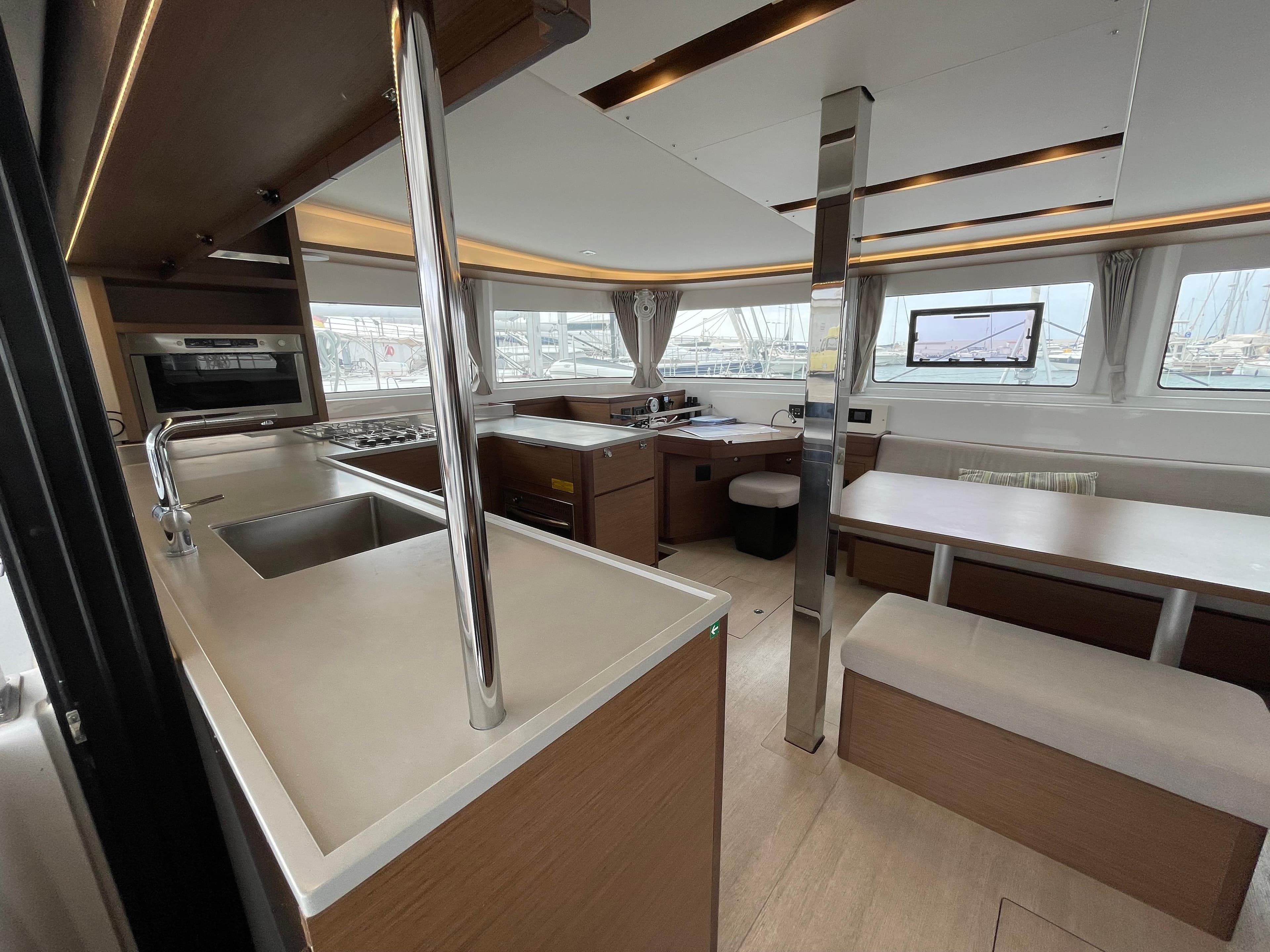 Modern interior of 2022 Lagoon 46 catamaran with spacious kitchen and dining area.