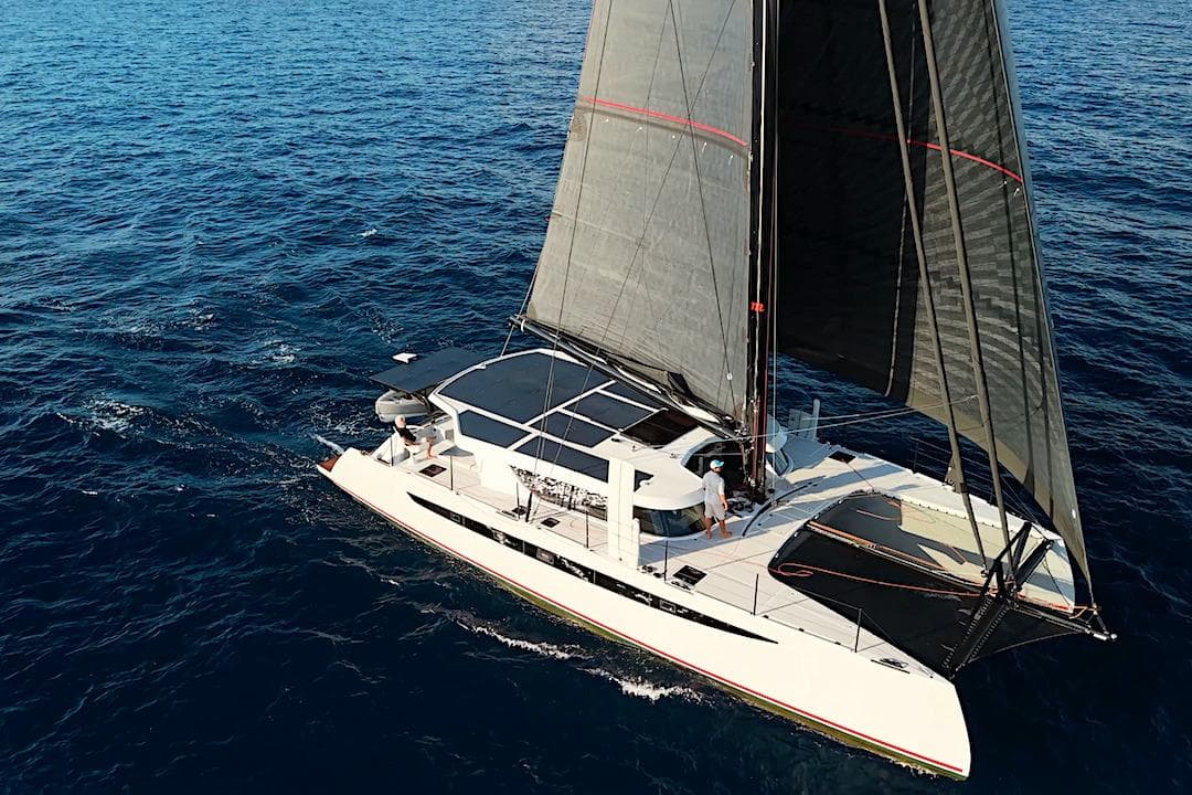 Aerial view of 2026 HH Catamarans HH60 sailing on open ocean waters.