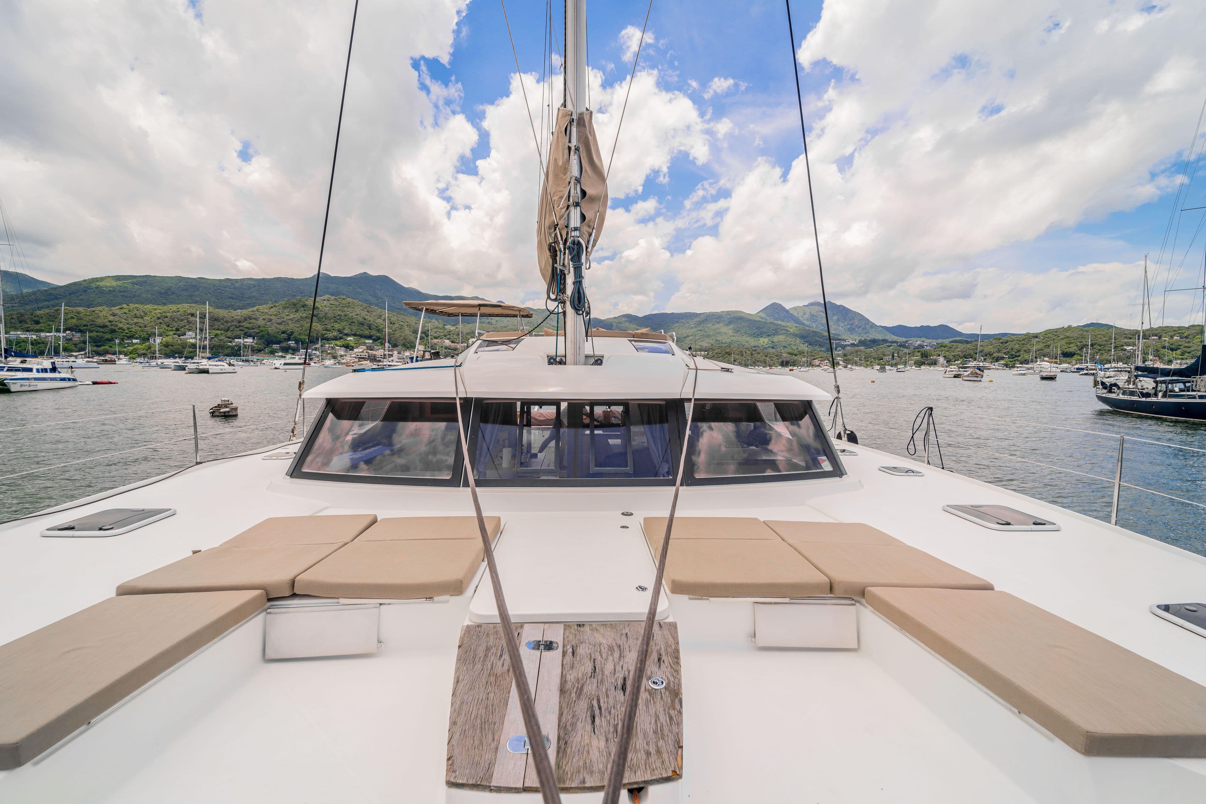 2016 Fountaine Pajot SABA 50 catamaran with spacious deck, docked in scenic marina.