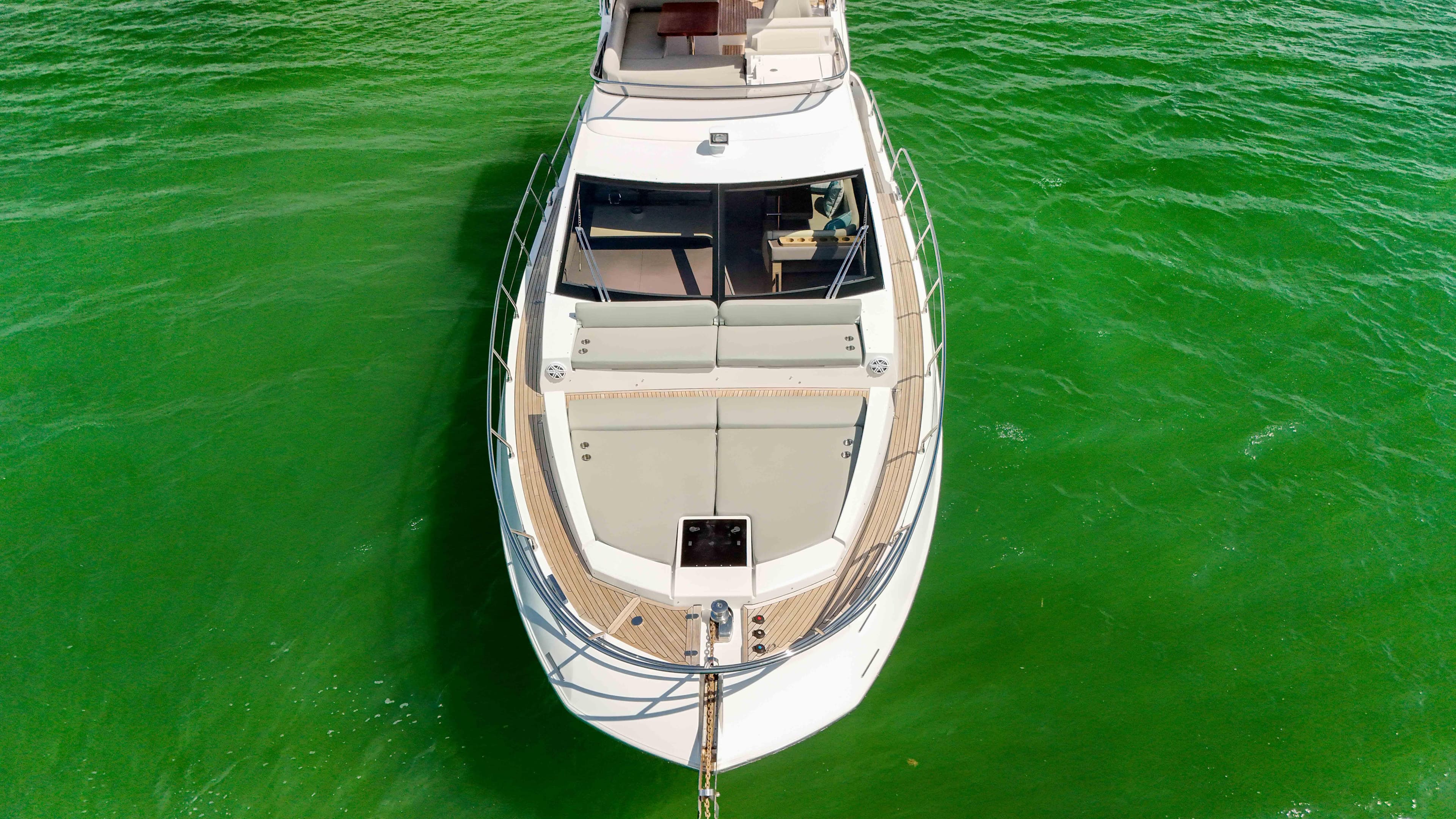 Aerial view of 2016 Azimut 50 Flybridge yacht on vibrant green water.