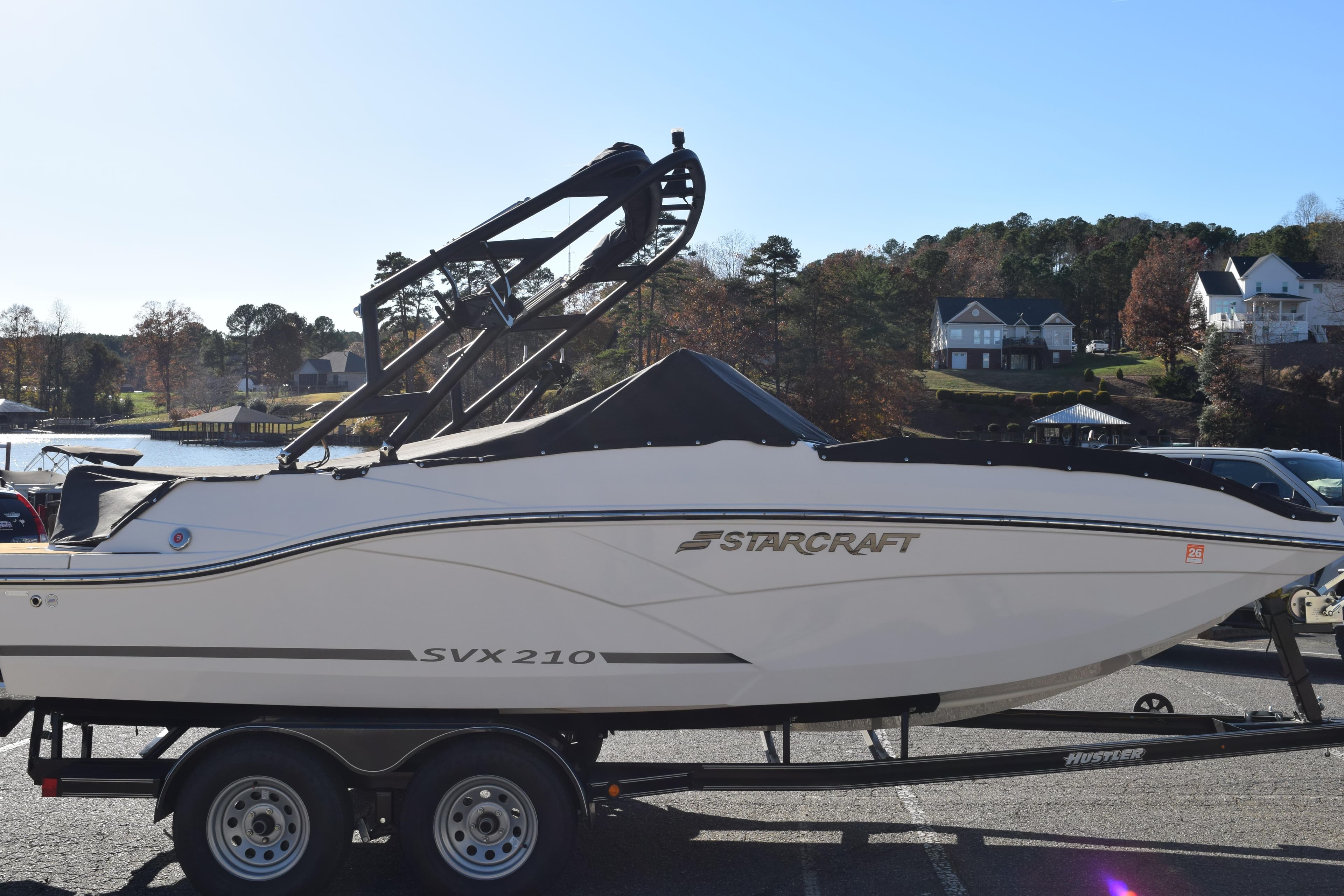 2023 Starcraft SVX 210 IO boat on trailer, parked near a scenic waterfront.