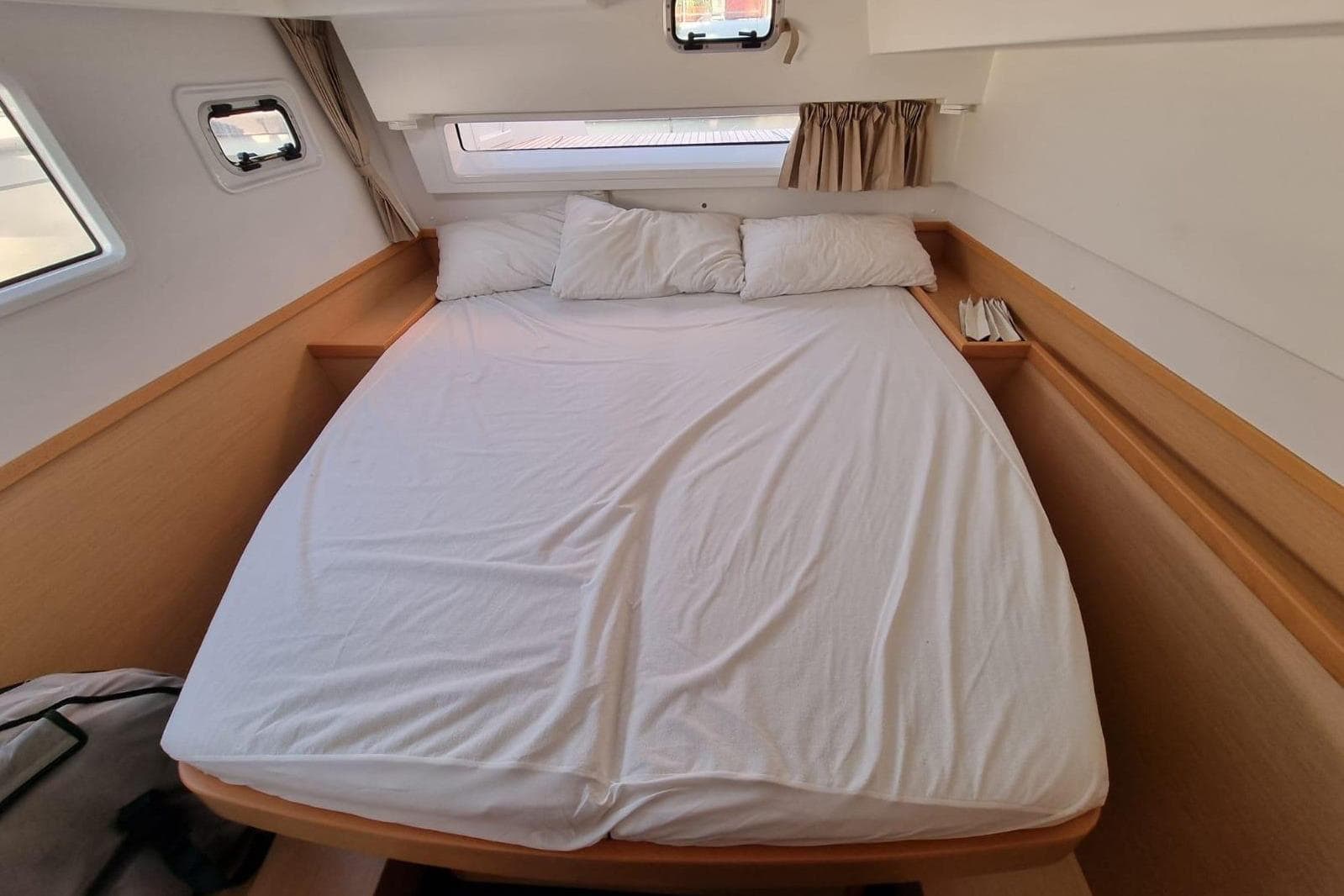 Cozy cabin interior of 2017 Lagoon 42 catamaran with comfortable bed and windows.