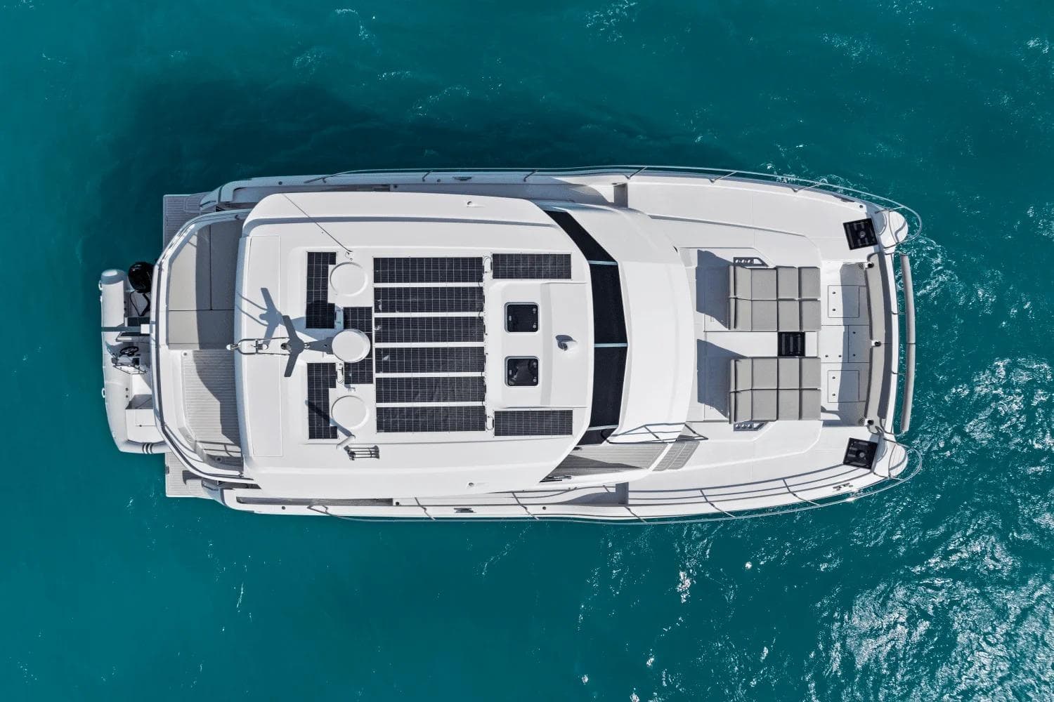Aerial view of 2026 Aquila 50 Yacht with solar panels on turquoise water.