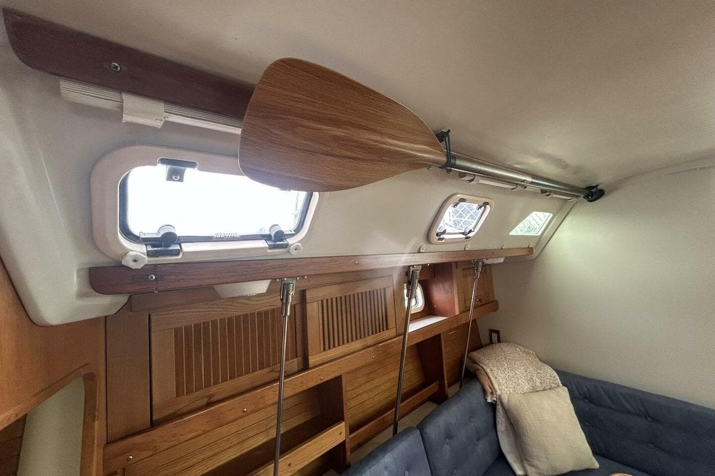 Interior of a 1995 Catalina 320 sailboat with wooden paddle and cozy seating.