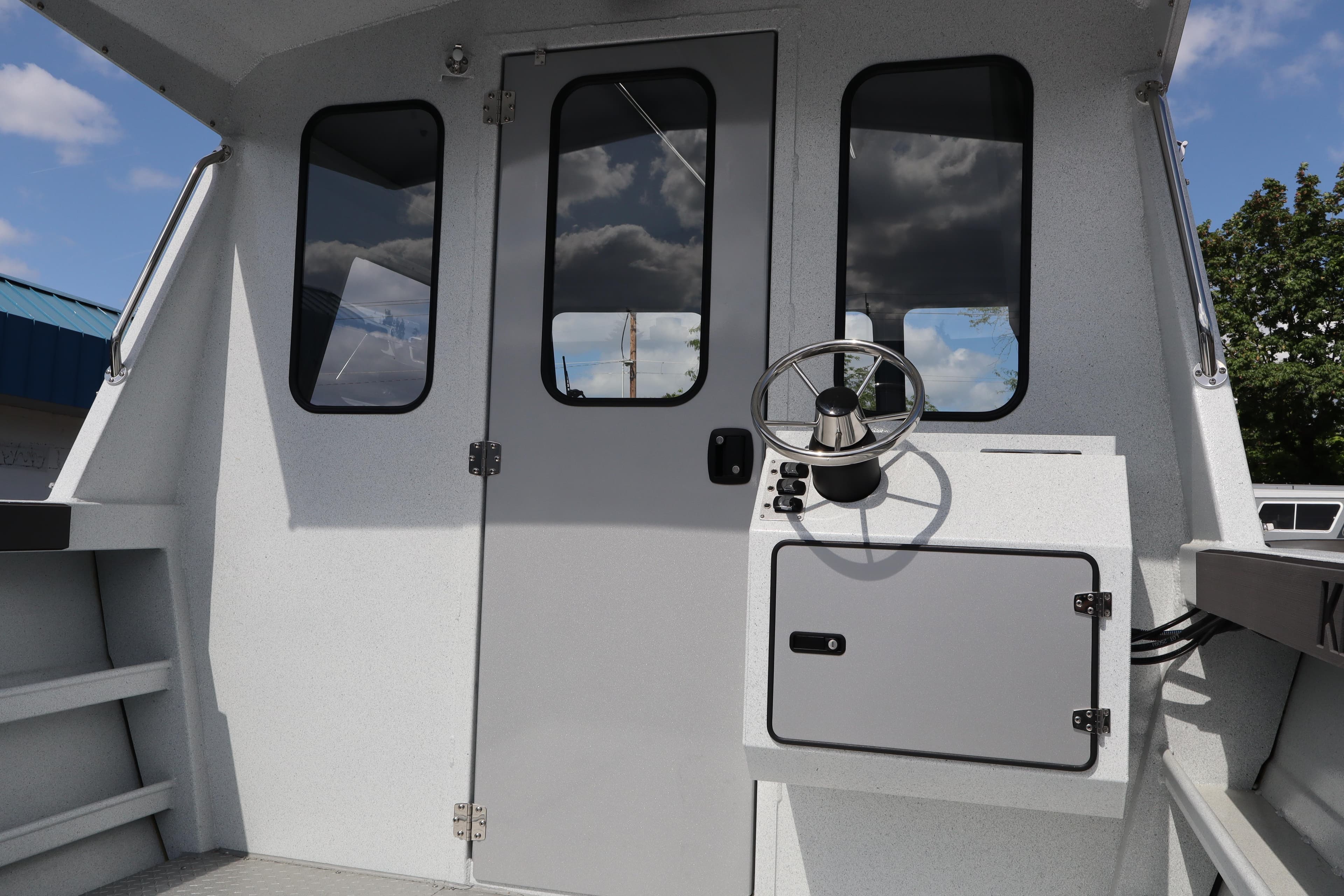 Interior view of 2026 KingFisher 2425 Escape HT boat helm with steering wheel.