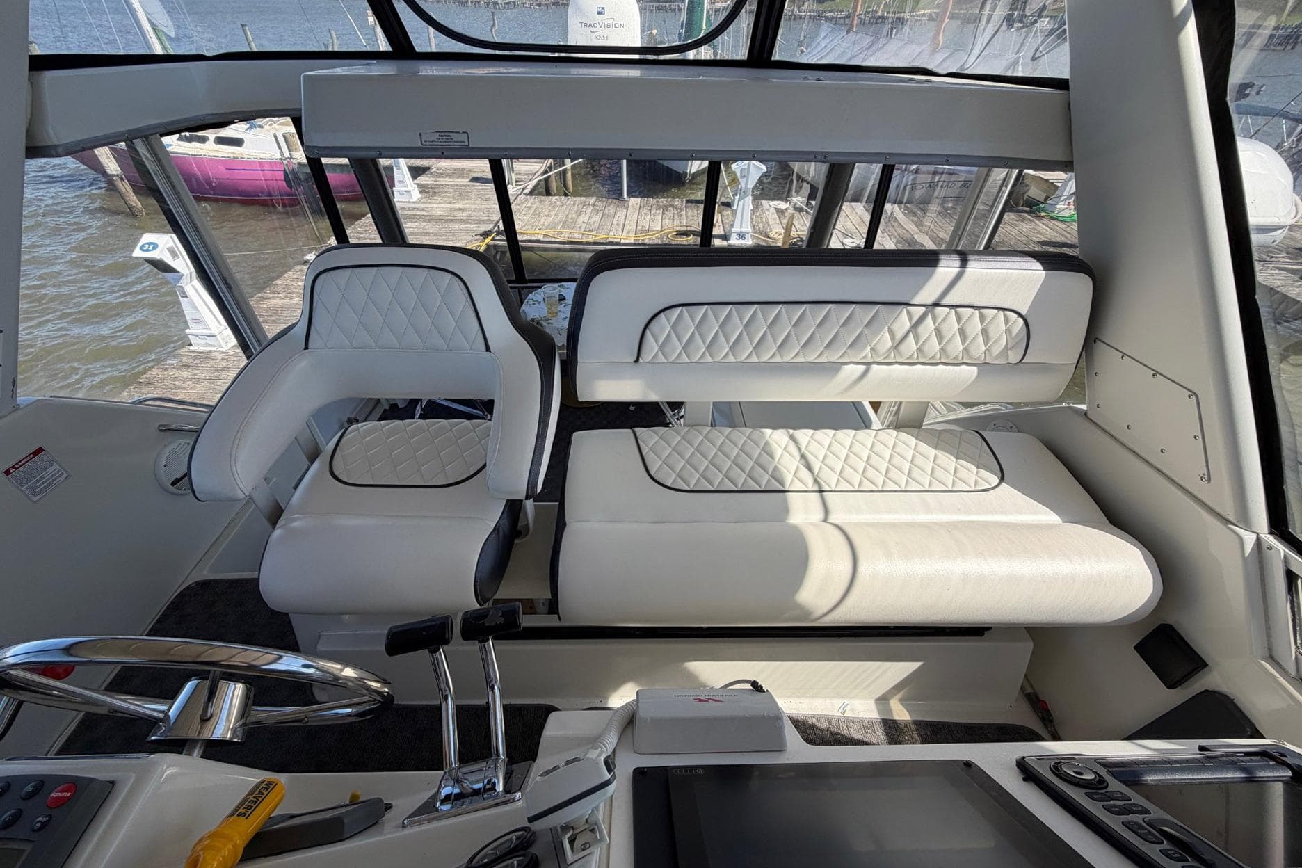 Interior of 1997 Carver 400 Cockpit Motor Yacht with white seating and steering controls.