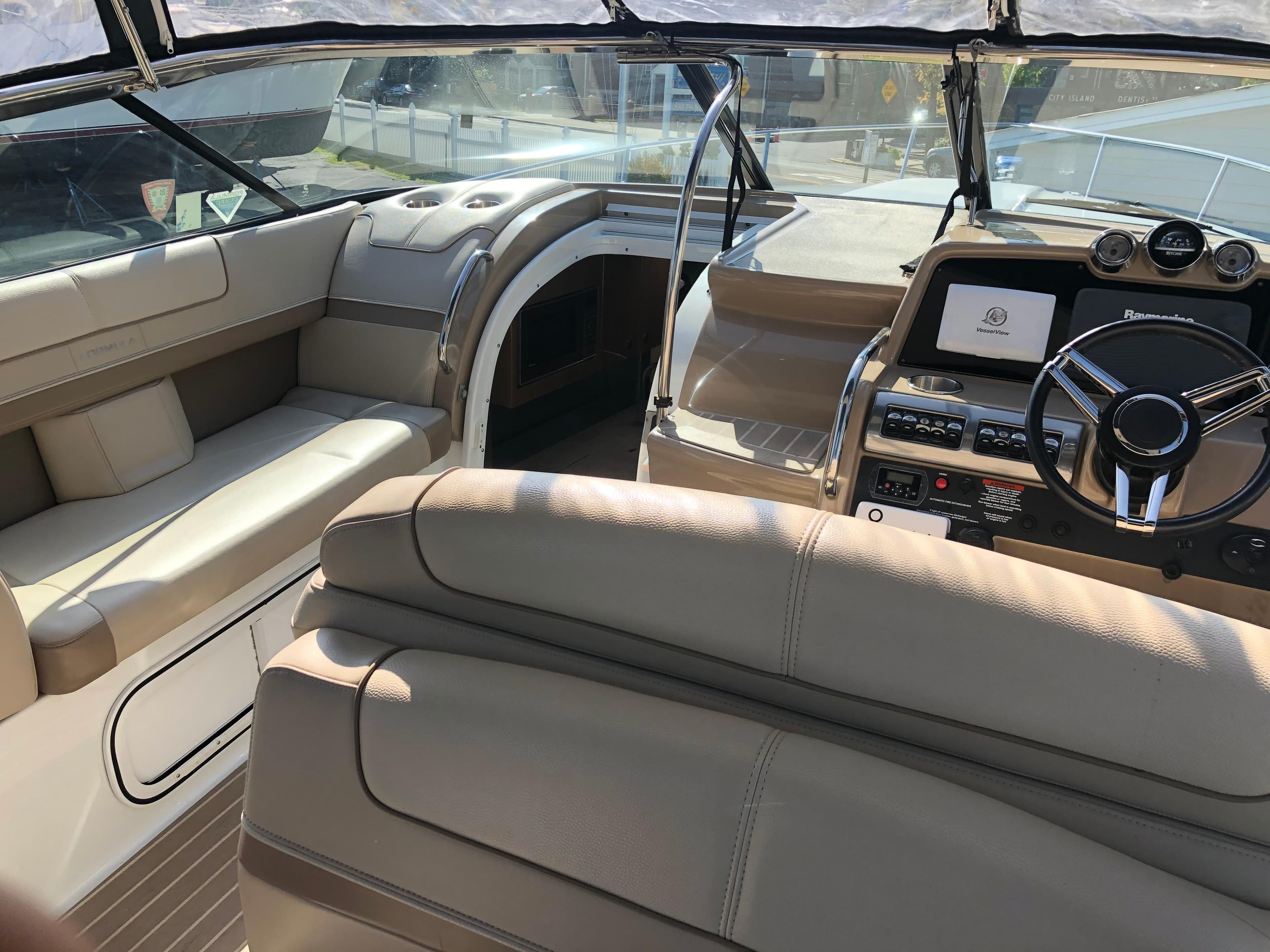 2013 Formula 350 Sun Sport boat interior with beige seating and modern dashboard.
