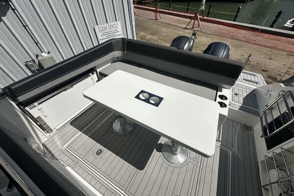 2024 Jeanneau Leader 9.0 WA boat deck with seating and table, docked at marina.
