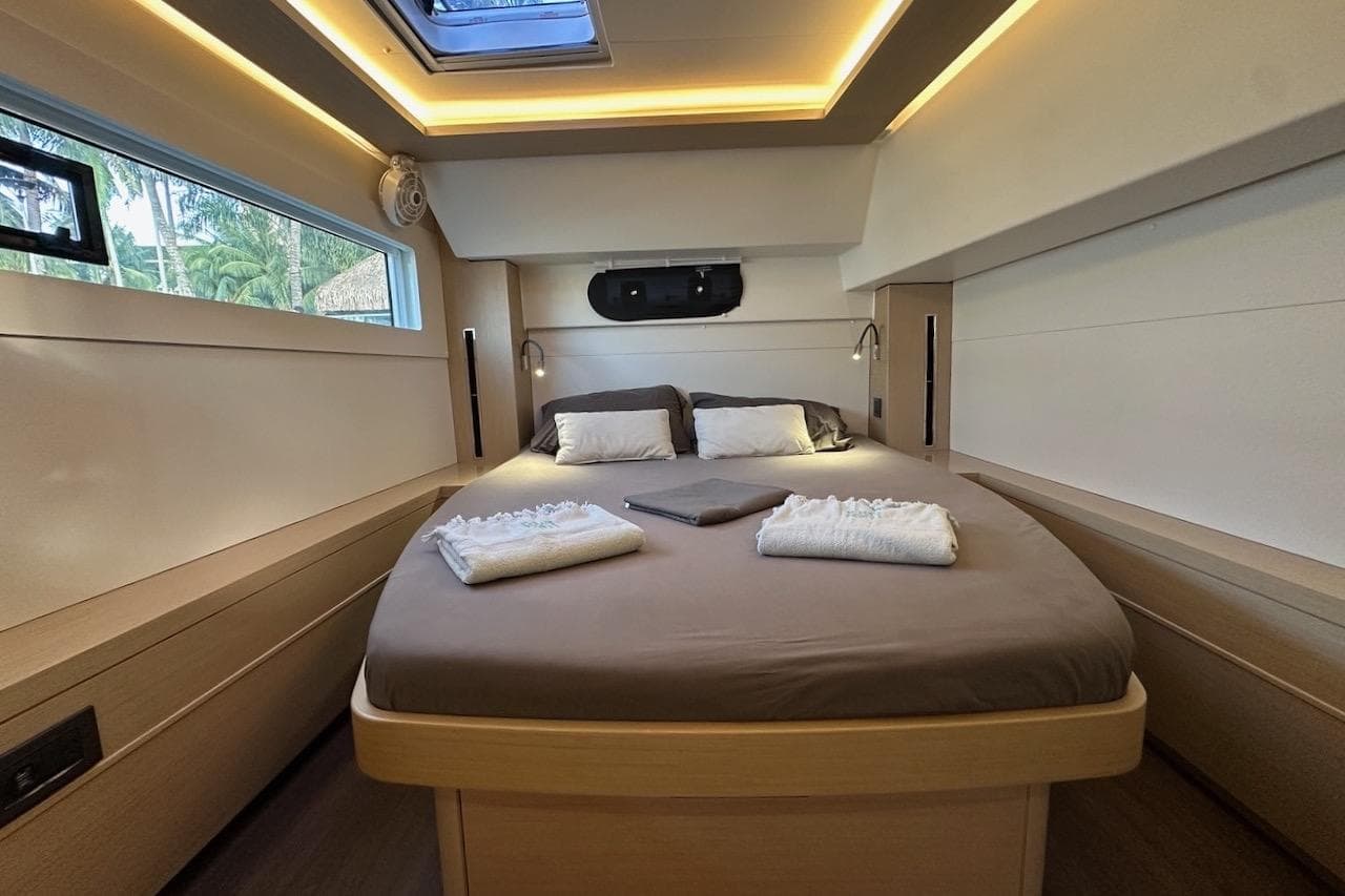 Luxurious cabin interior of 2023 Lagoon 46 yacht with cozy bed and modern lighting.