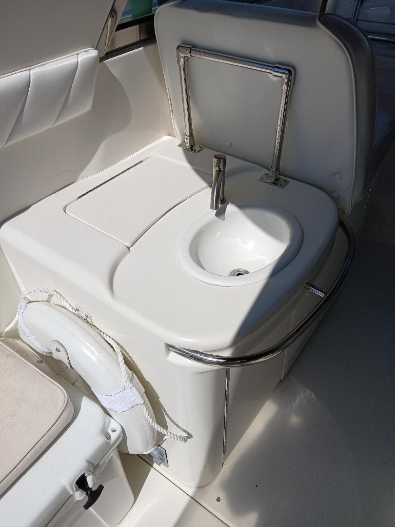 1997 Sea Ray 370 Sundancer boat interior with compact sink and seating area.