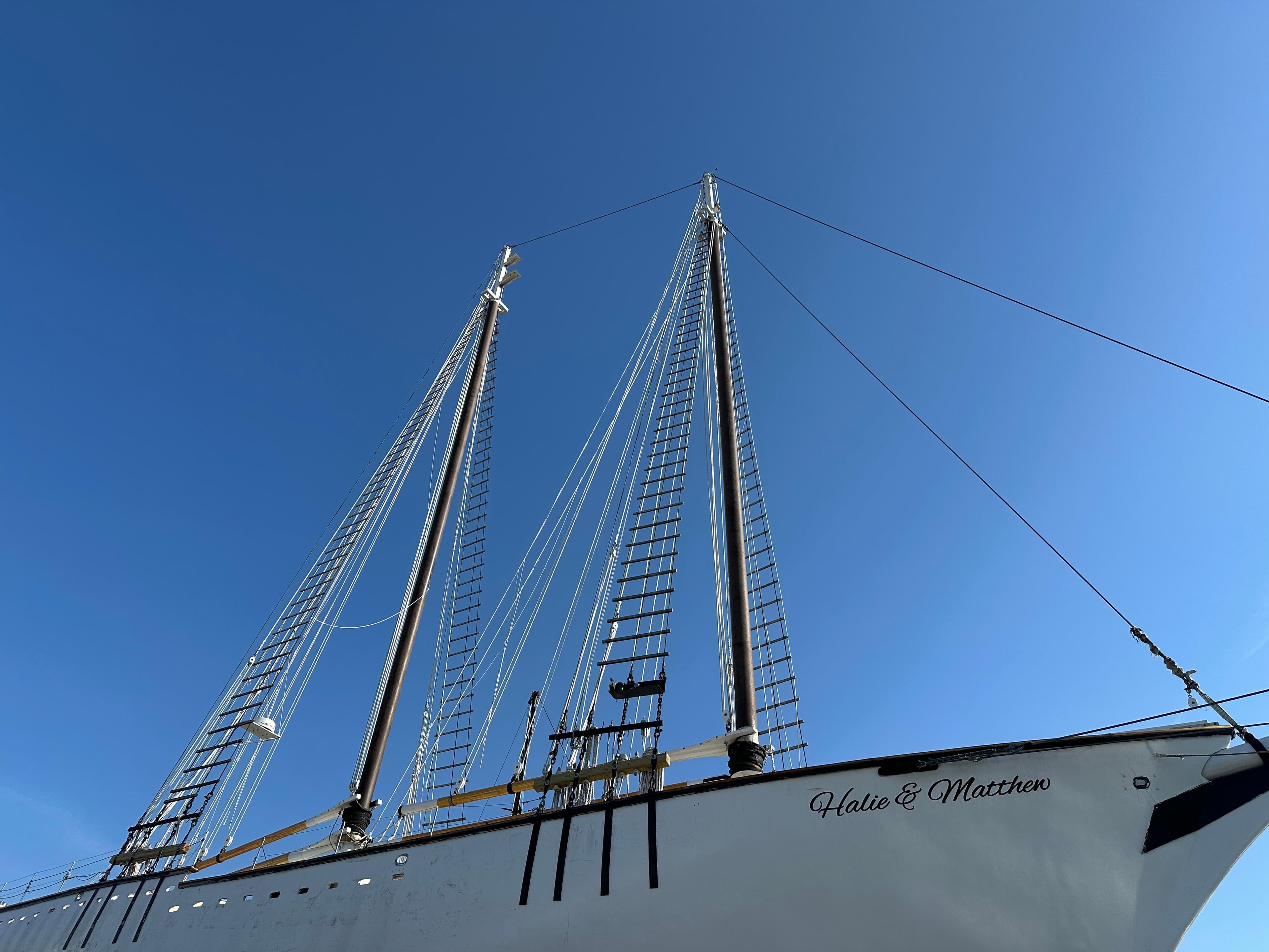 Schooner HARRIS and BISHOP 2006 with tall masts against a clear blue sky.