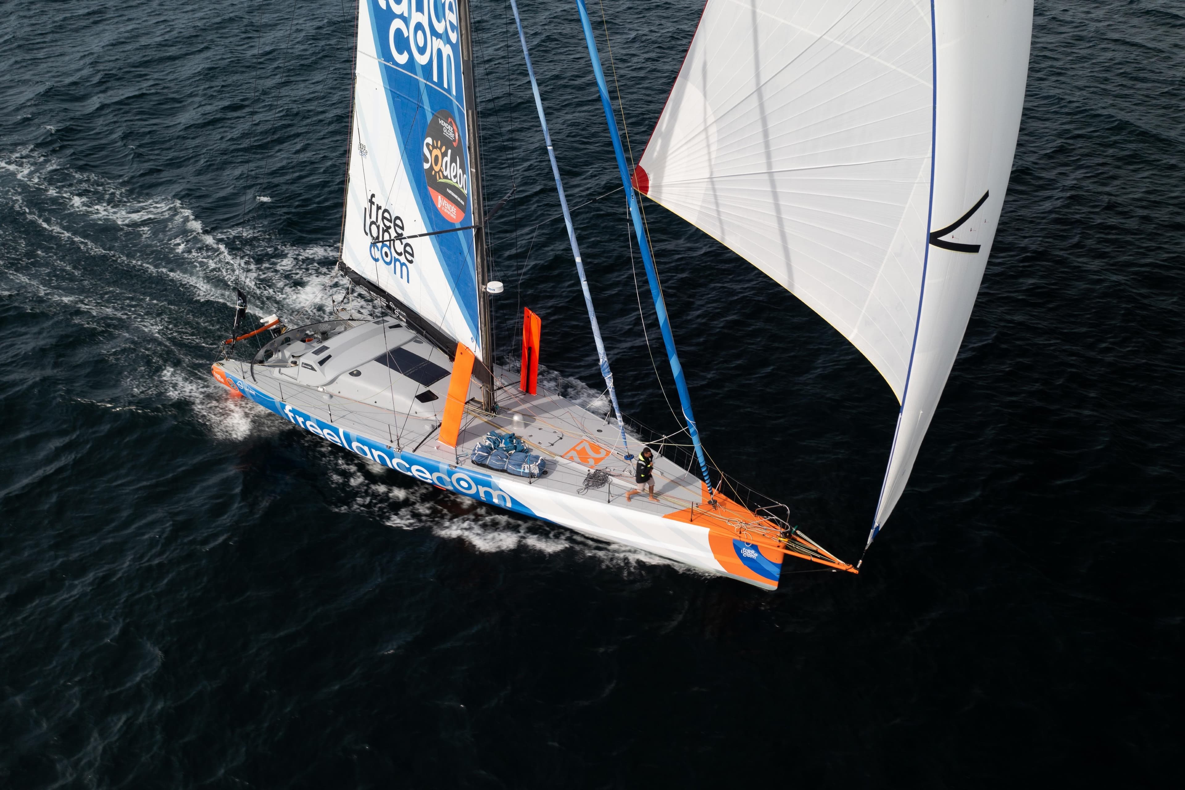 Aerial view of a 2007 Custom IMOCA sailboat racing on open water.