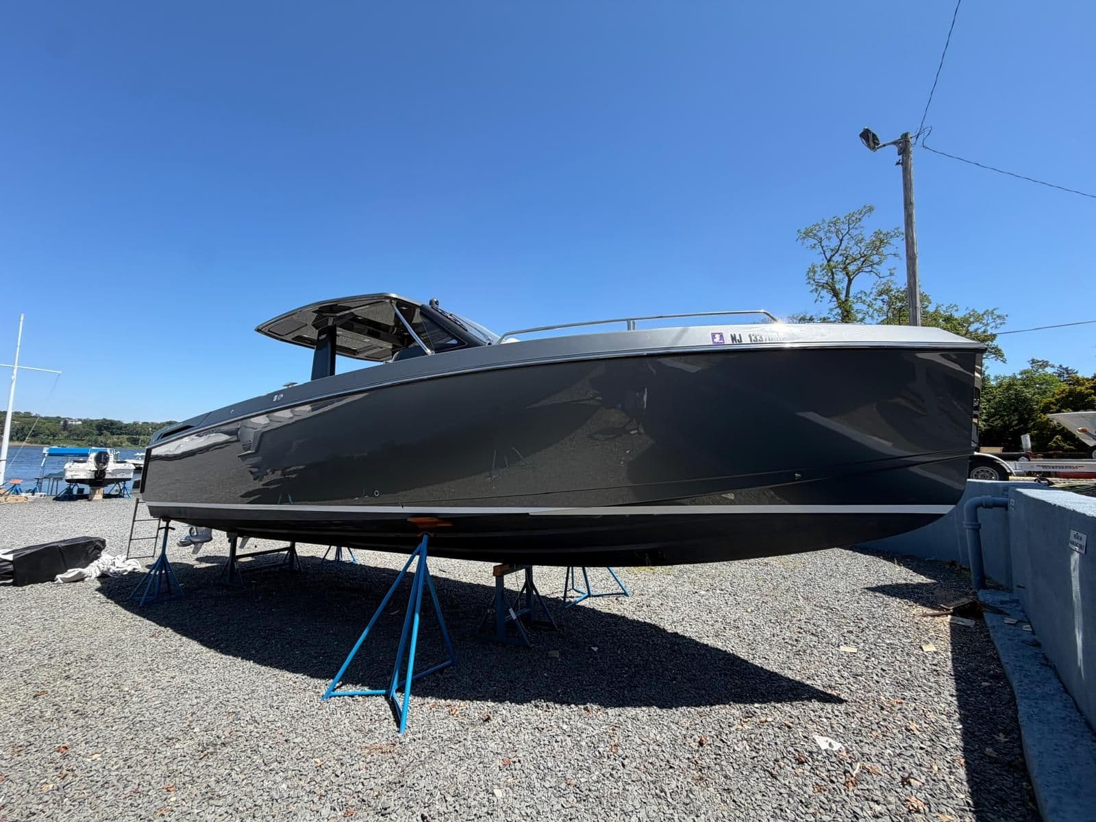 2024 Schaefer V33 boat on stands, blue sky.