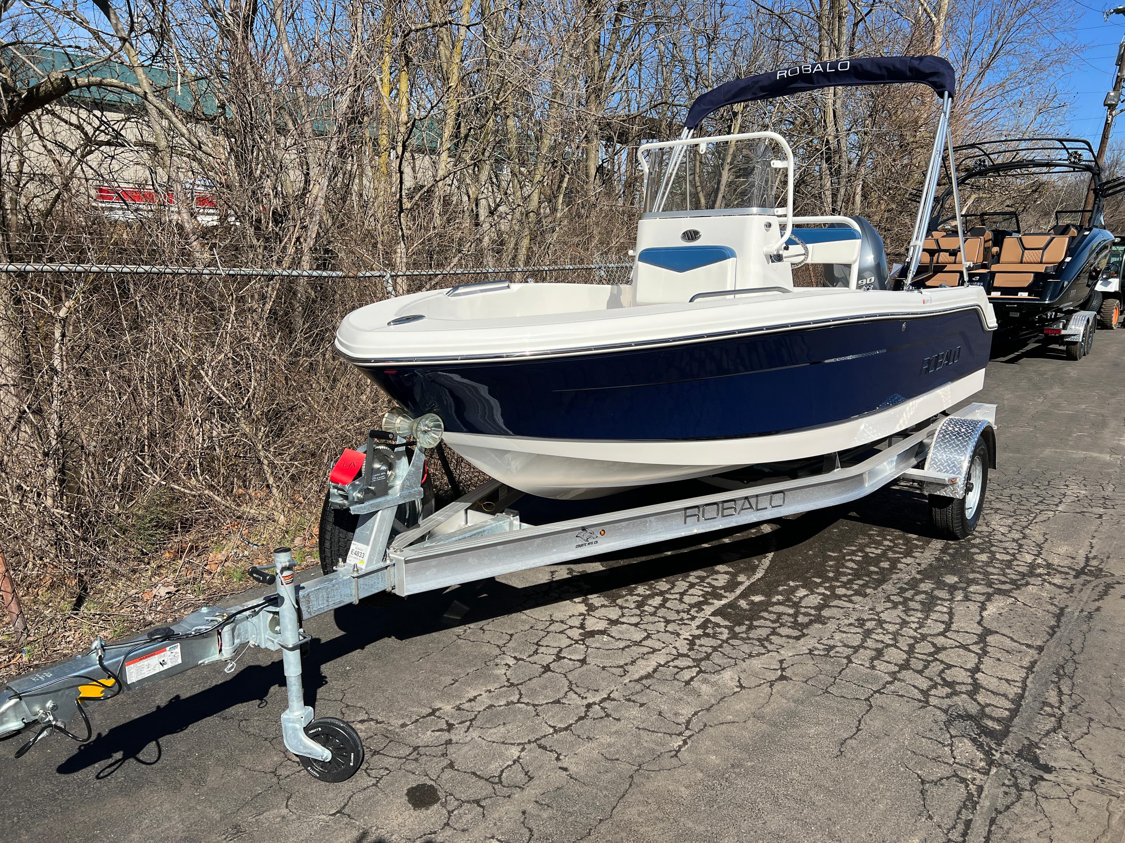 2025 Robalo R160 Center Console boat on trailer, parked outdoors.