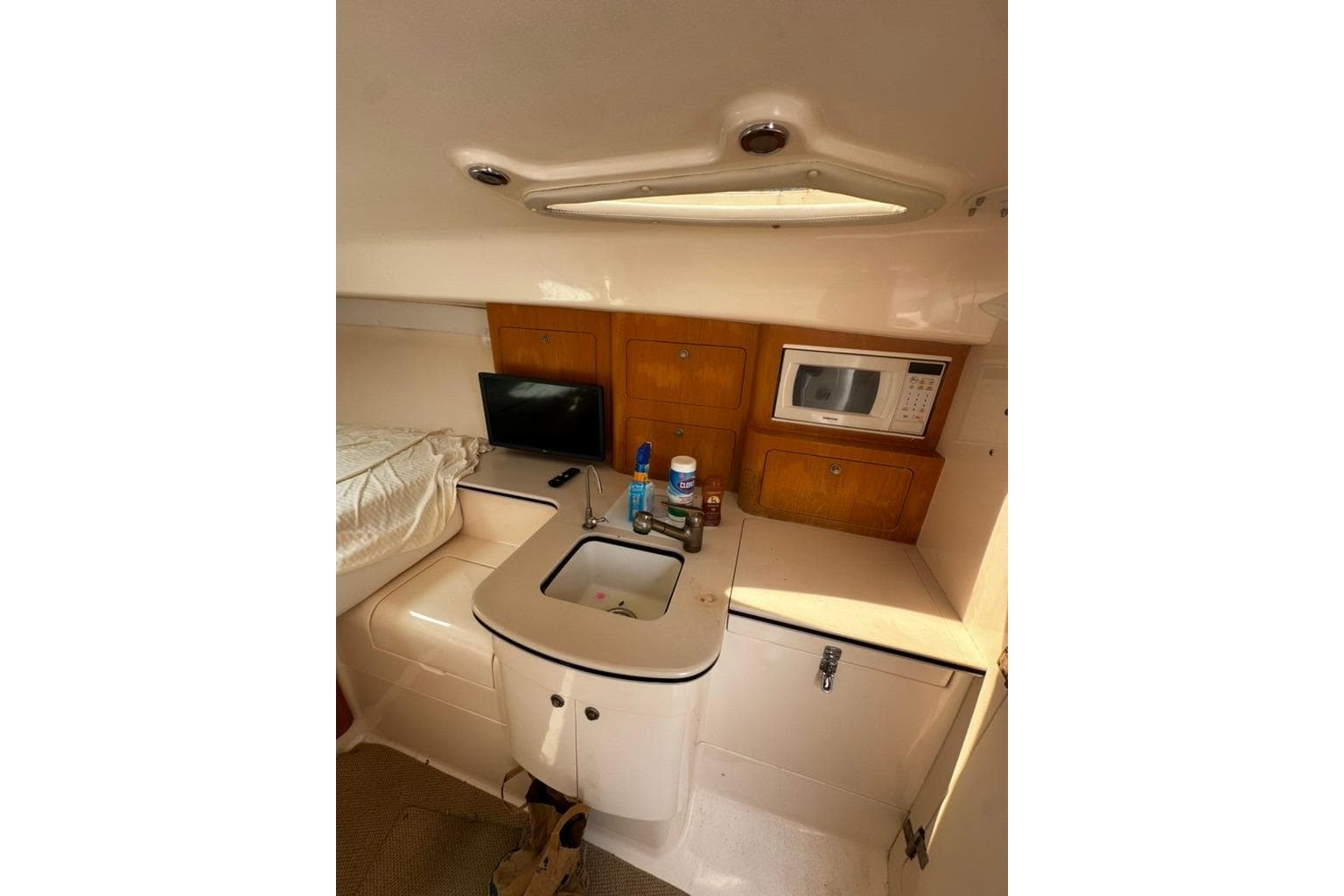 2004 Intrepid 377 Walkaround cabin with kitchenette, sink, microwave, and storage cabinets.