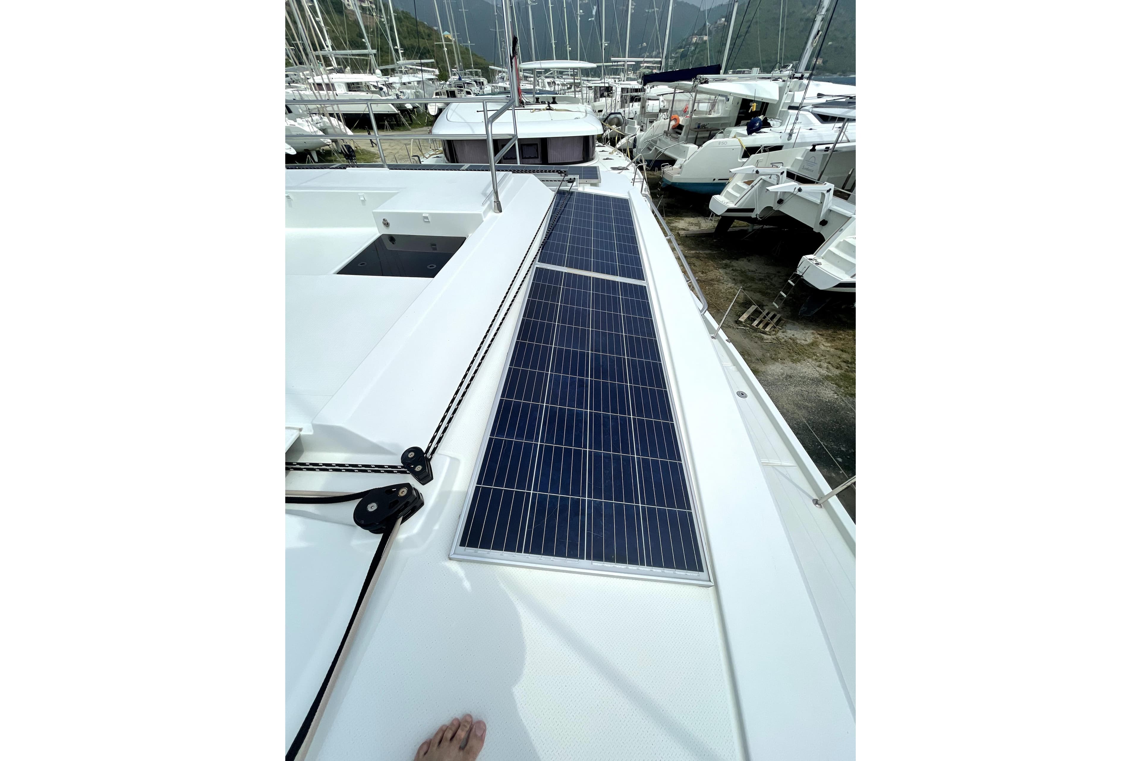2019 Fountaine Pajot Saona 47 catamaran with solar panels on deck in marina.