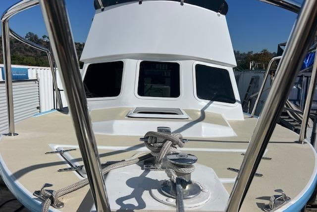 1971 Mariners BAJA 30 boat deck with ropes and railing, docked under clear blue sky.