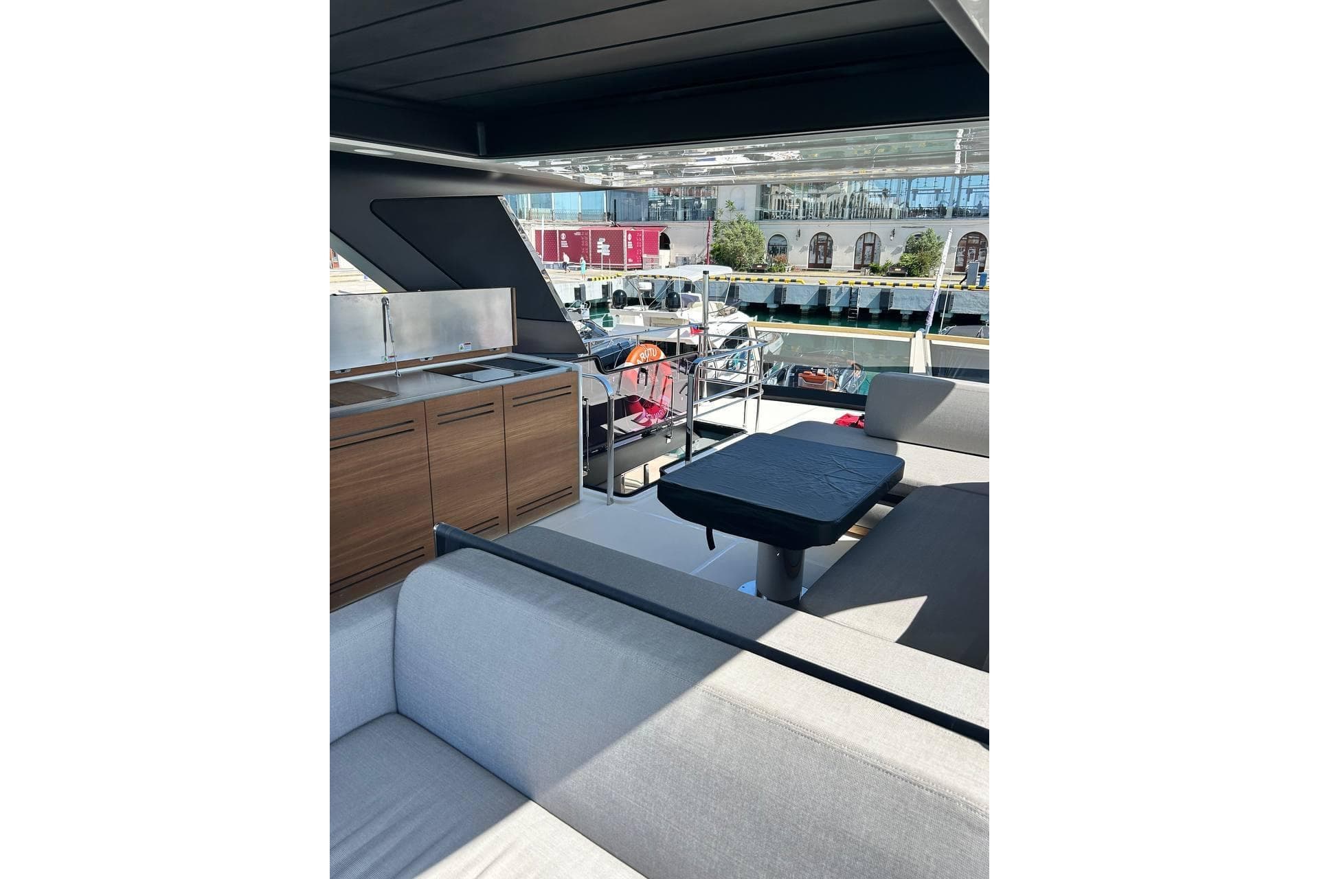 Luxurious interior of 2023 Cranchi Sessantasette 67 yacht with modern seating and kitchenette.
