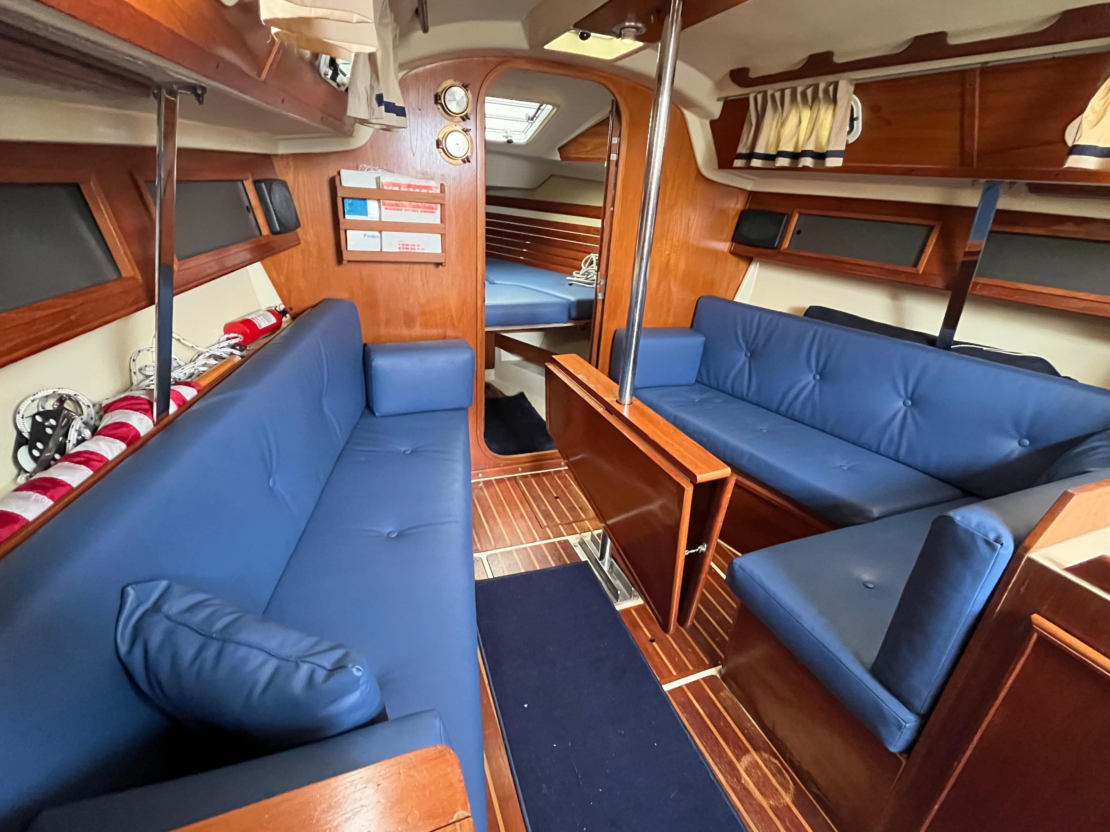 Interior of 1986 Pearson 33-2 sailboat with blue seating and wooden accents.