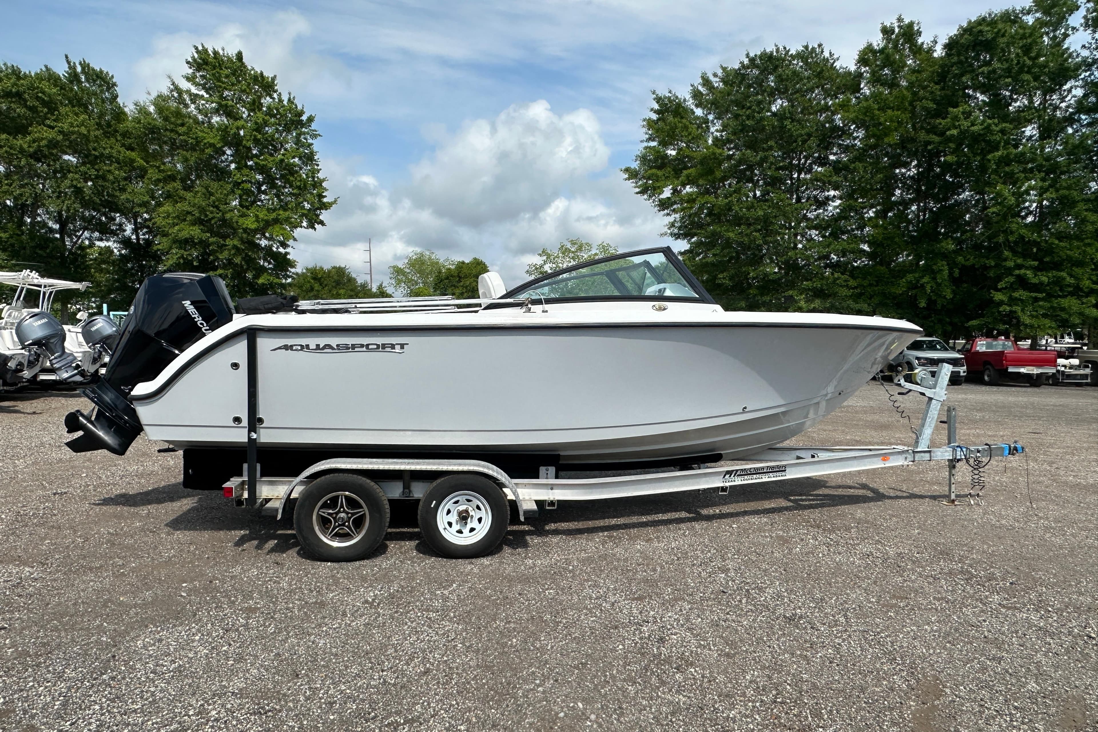 2024 Aquasport 2200 Dual Console boat on trailer, parked outdoors.
