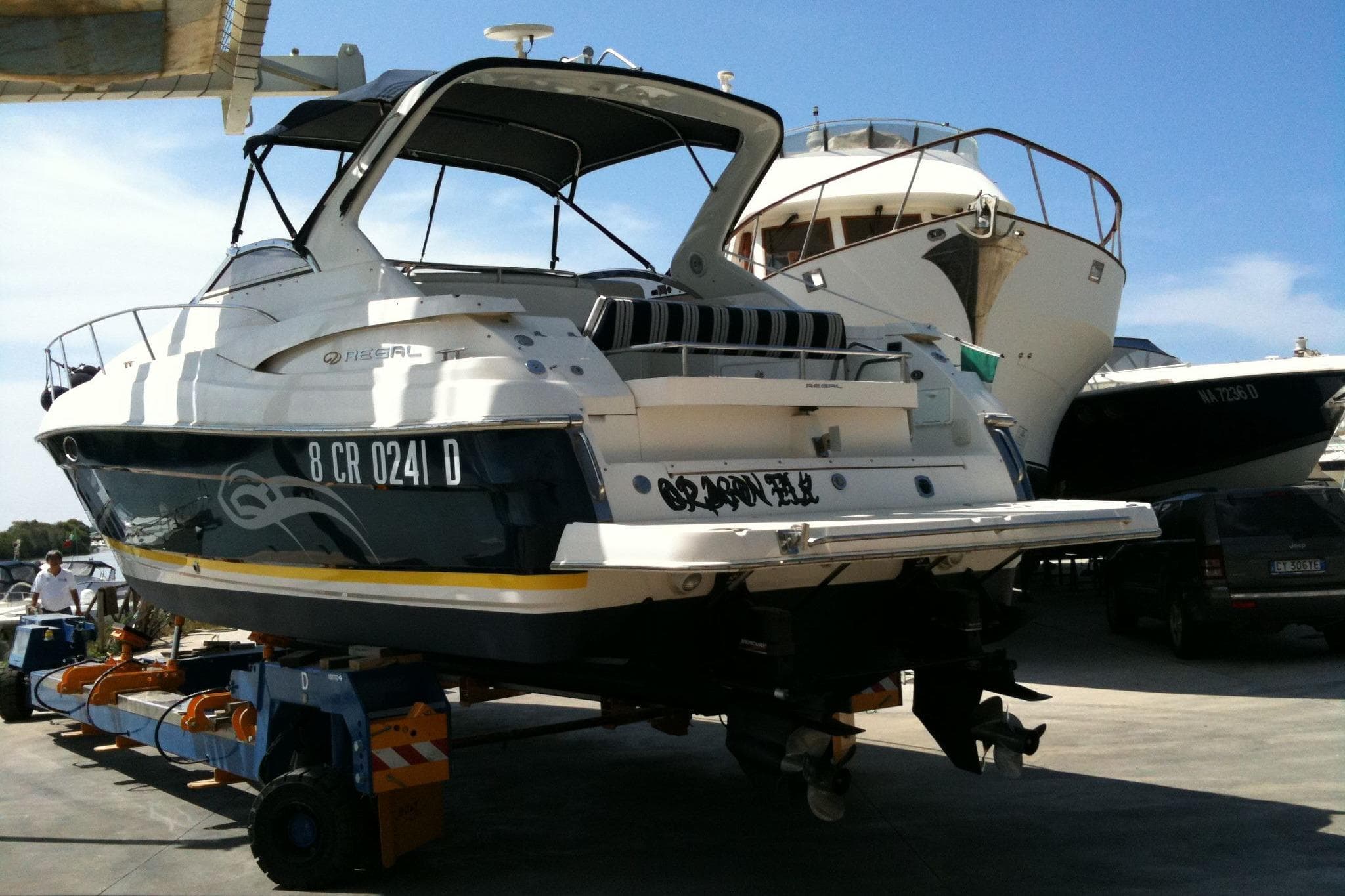 2006 Regal Commodore 3860 yacht on trailer in marina under clear blue sky.