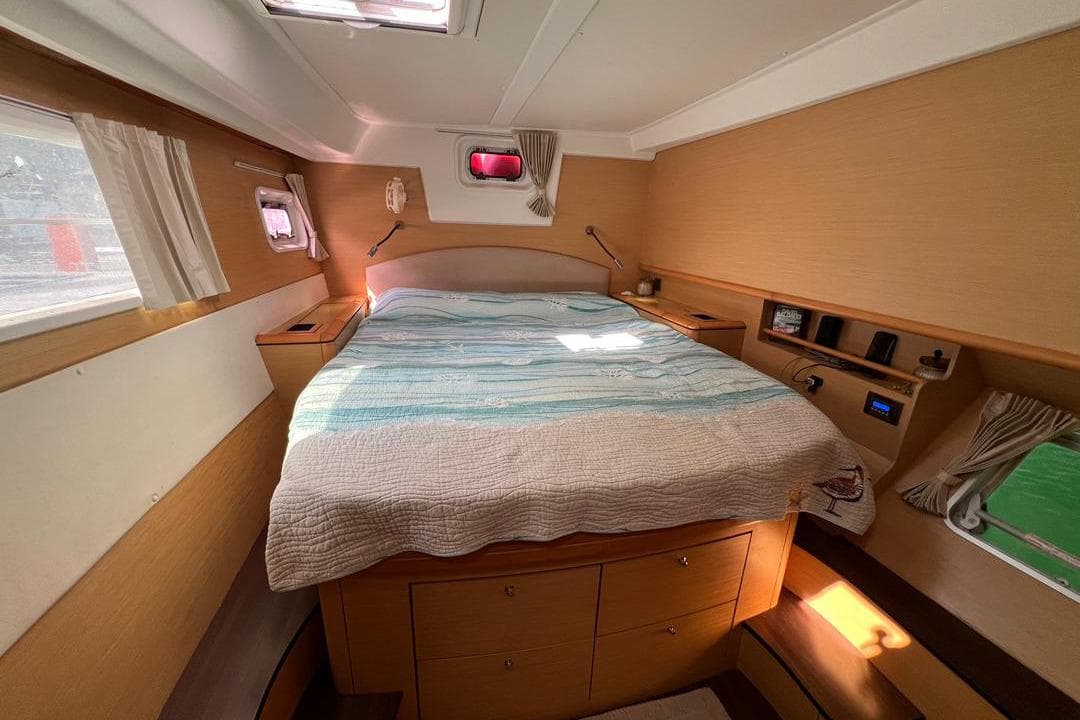 Luxurious cabin interior of a 2012 Lagoon 500 yacht with cozy bedding and ample storage.