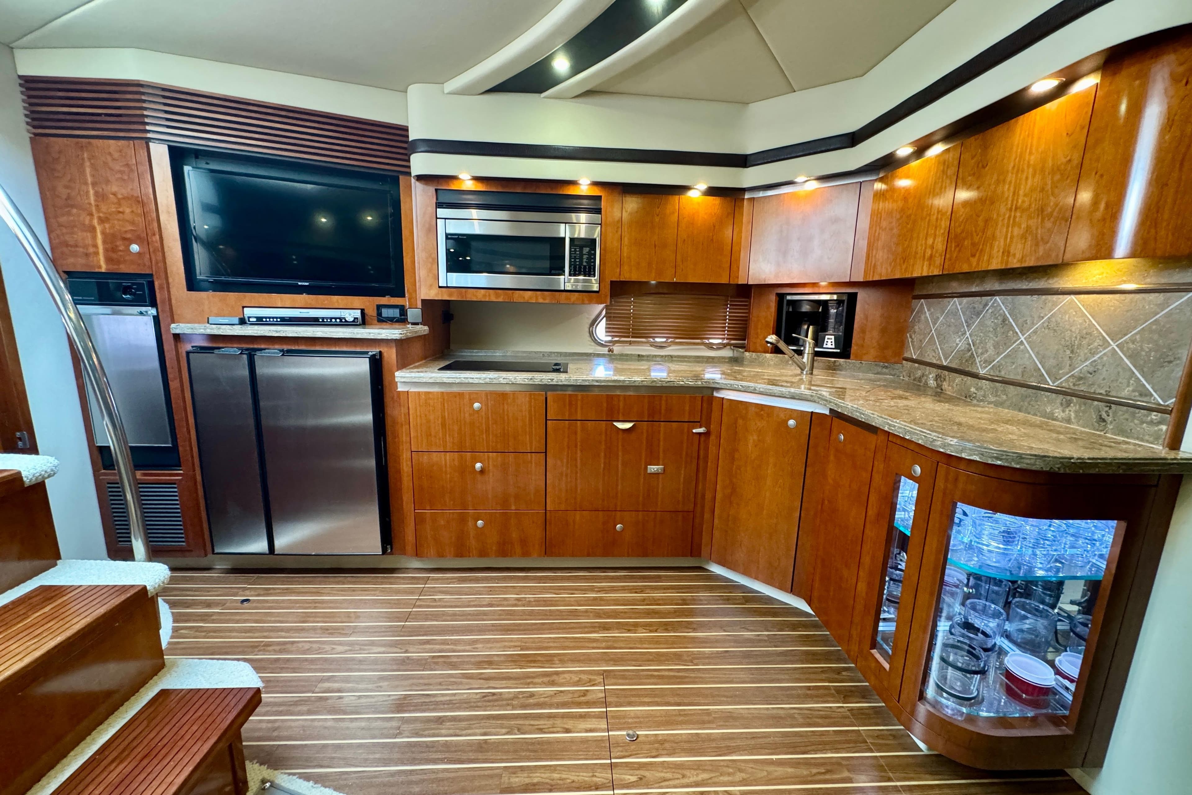 Luxurious 2009 Cruisers Yachts 520 Sports Coupe kitchen with wood cabinetry and modern appliances.