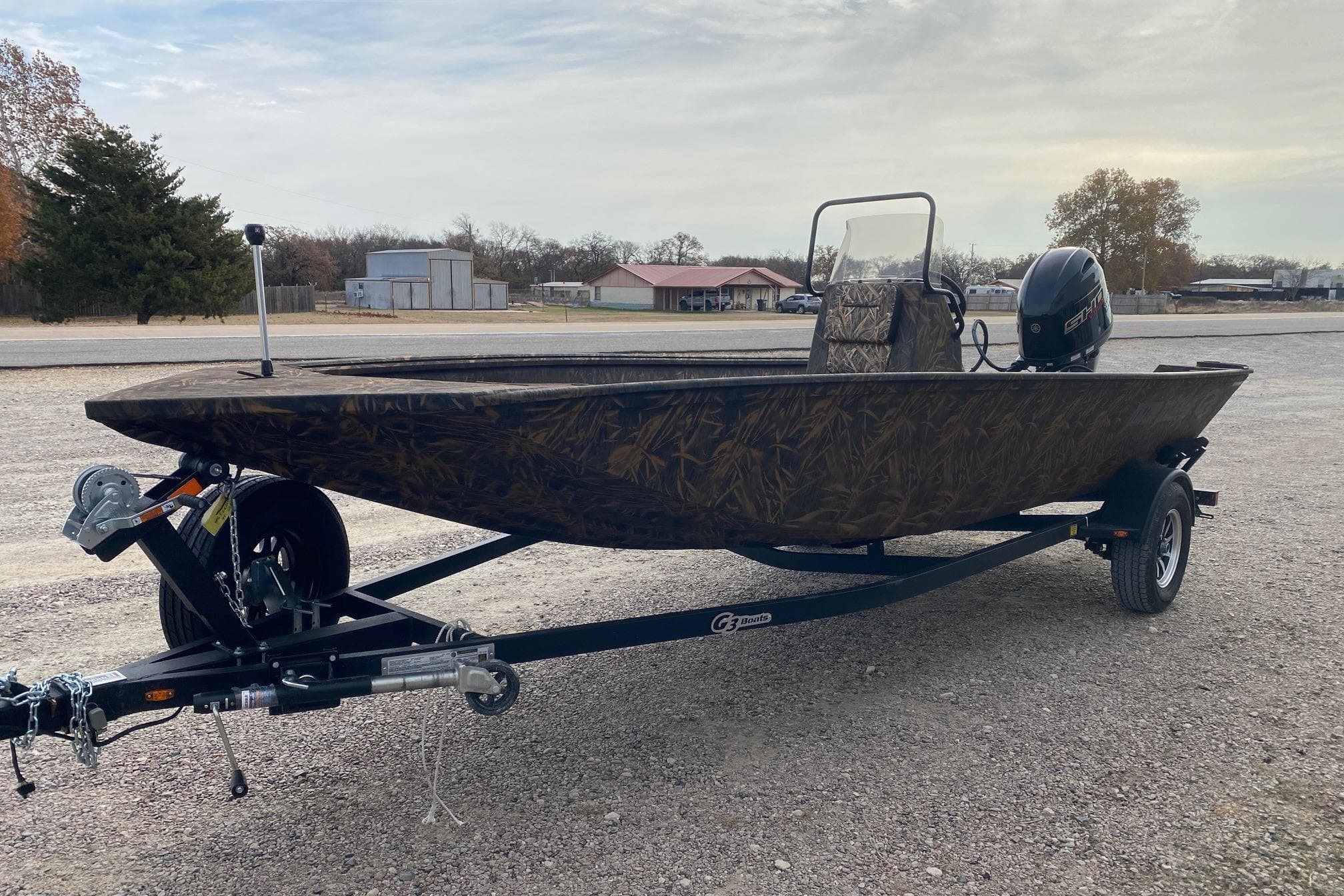 2026 G3 Gator Tough 18 CC boat on trailer, camo design, parked outdoors.