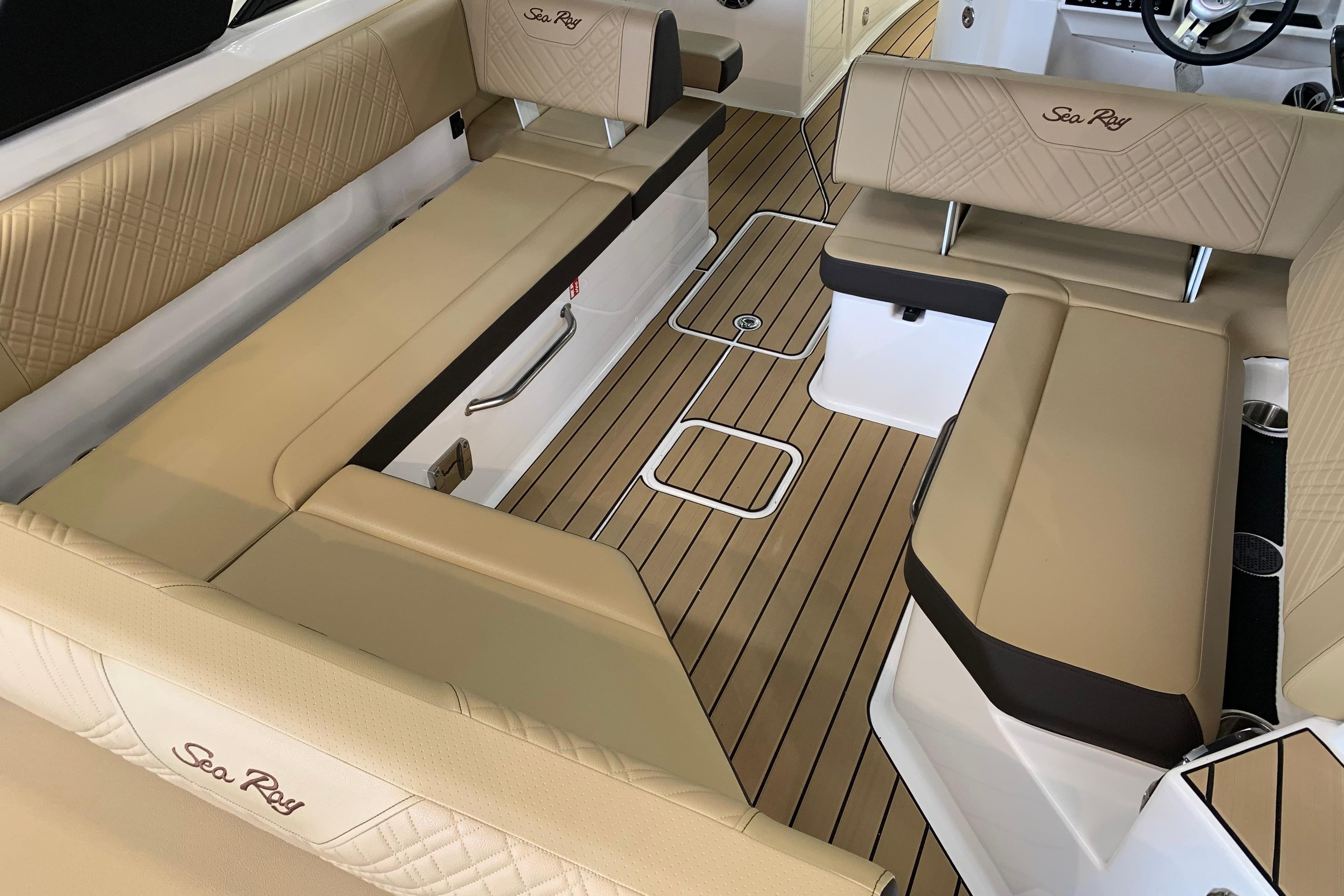 Luxurious interior of 2025 Sea Ray SDX 270 boat with beige seating and wood flooring.