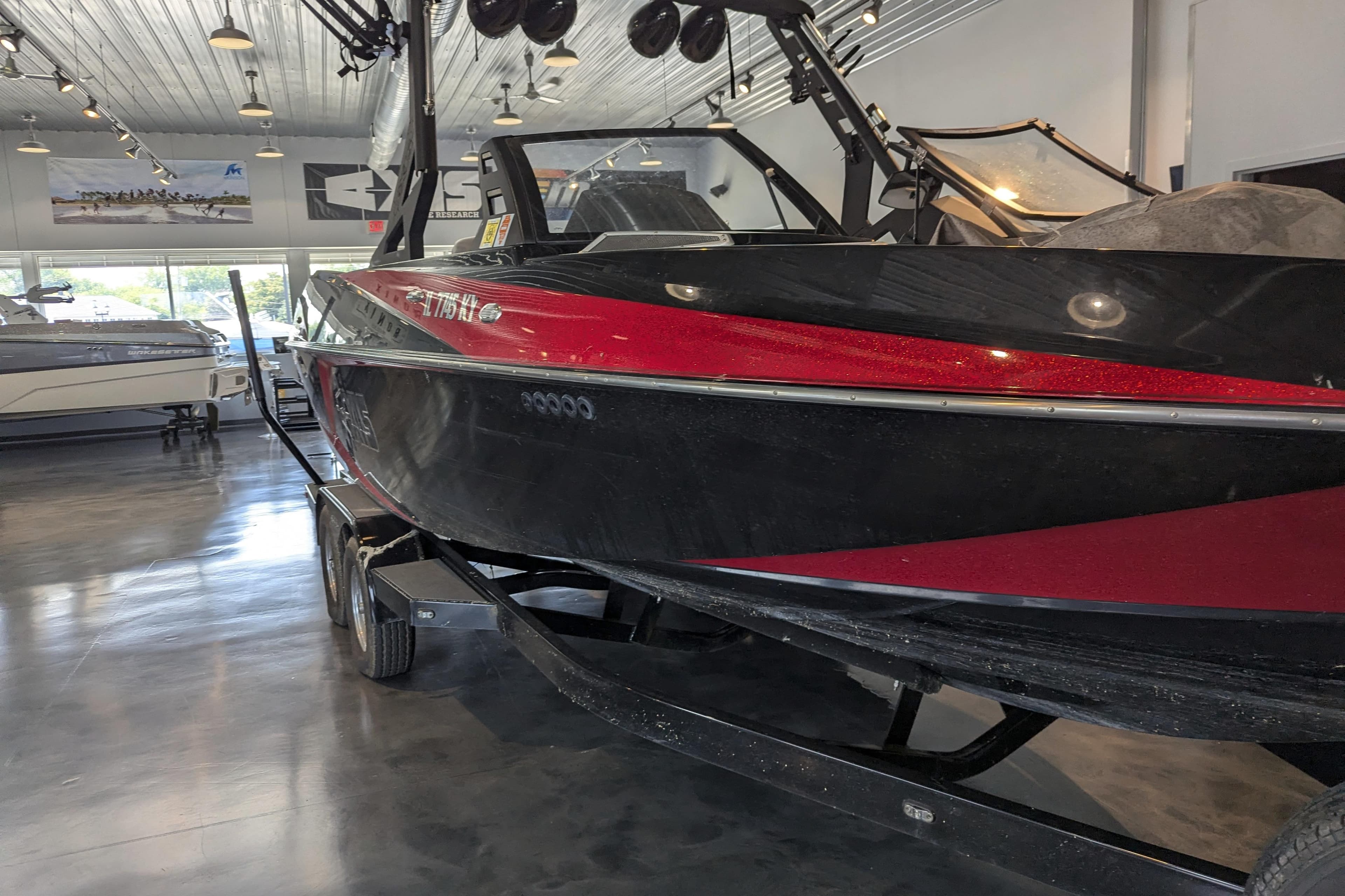 2018 Axis T23 boat in showroom, black and red design, on trailer.