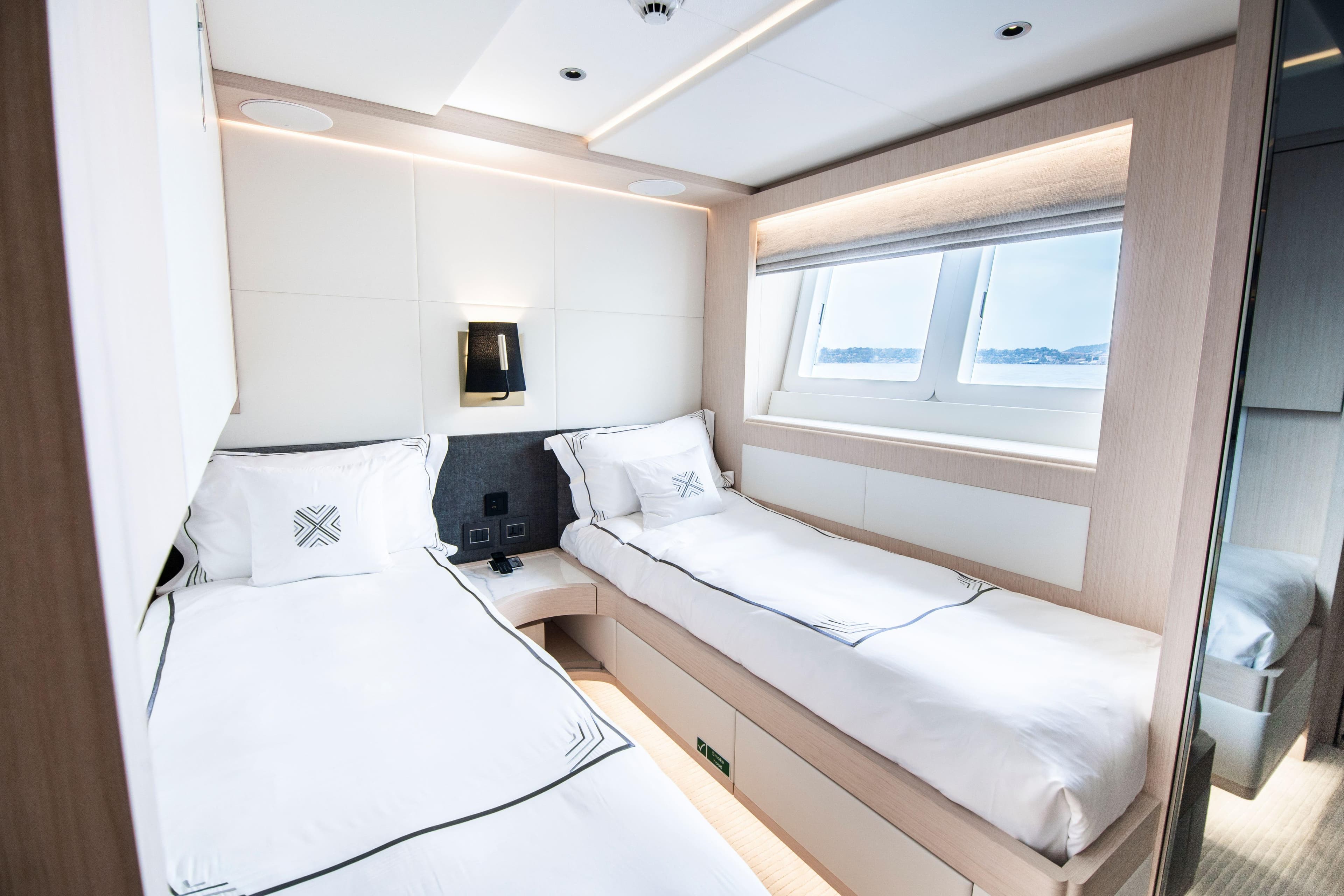Luxurious twin cabin interior on 2025 Majesty 100 yacht, featuring modern design and ocean view.