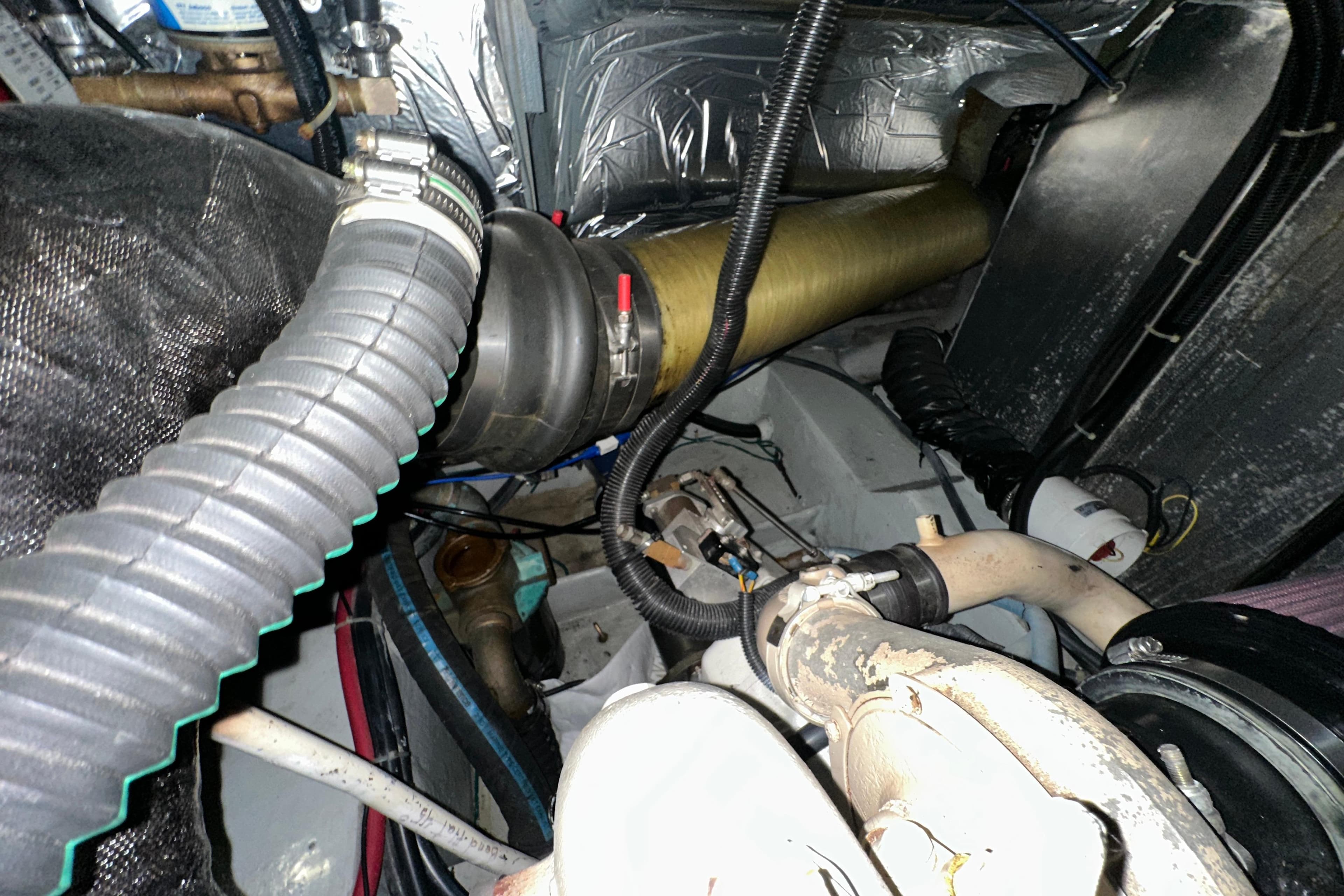 Engine room of 1998 Carver 445 Aft Cabin Motor Yacht, showing hoses and mechanical components.