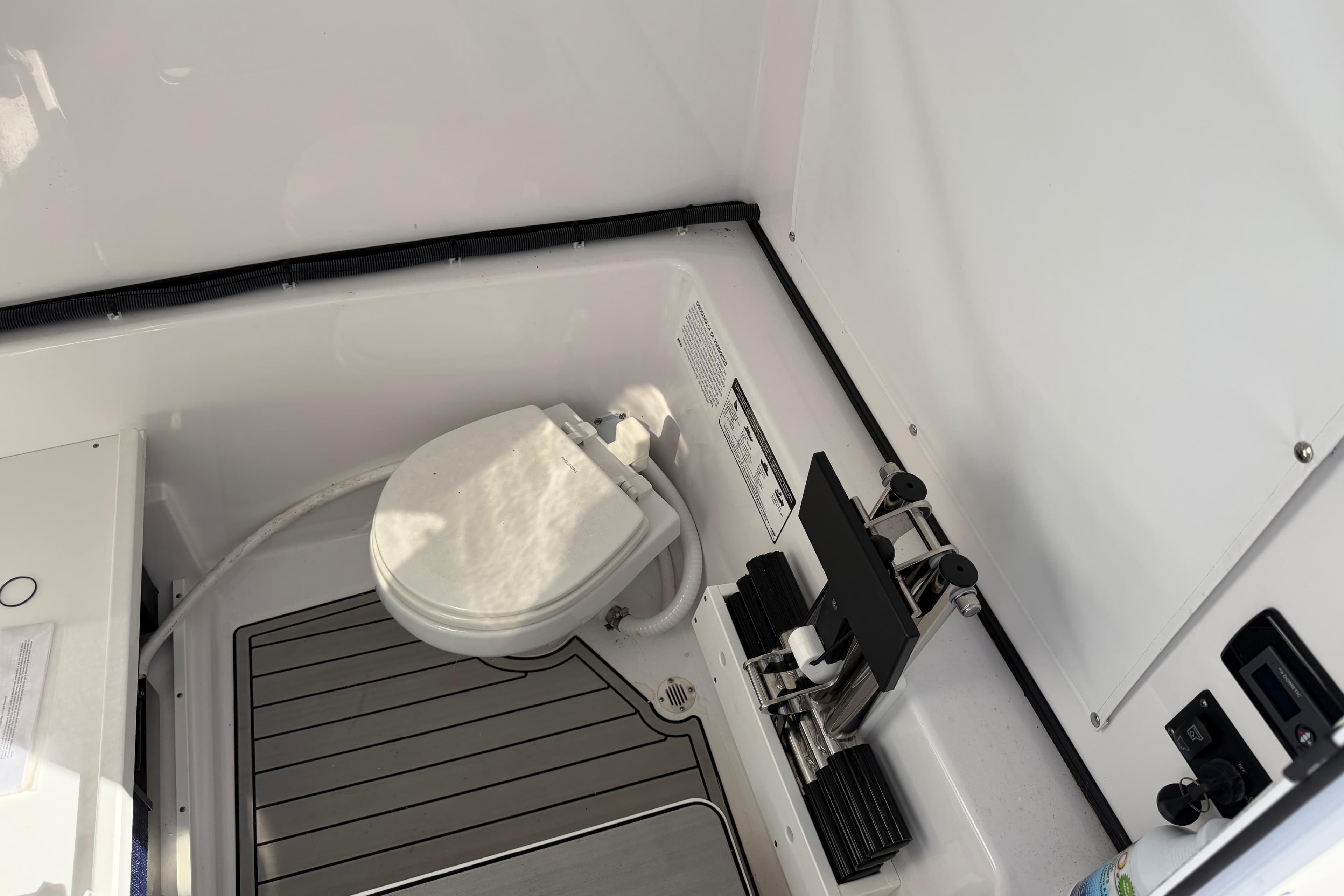 2024 Sportsman Open 282TE Center Console boat interior with toilet and equipment.