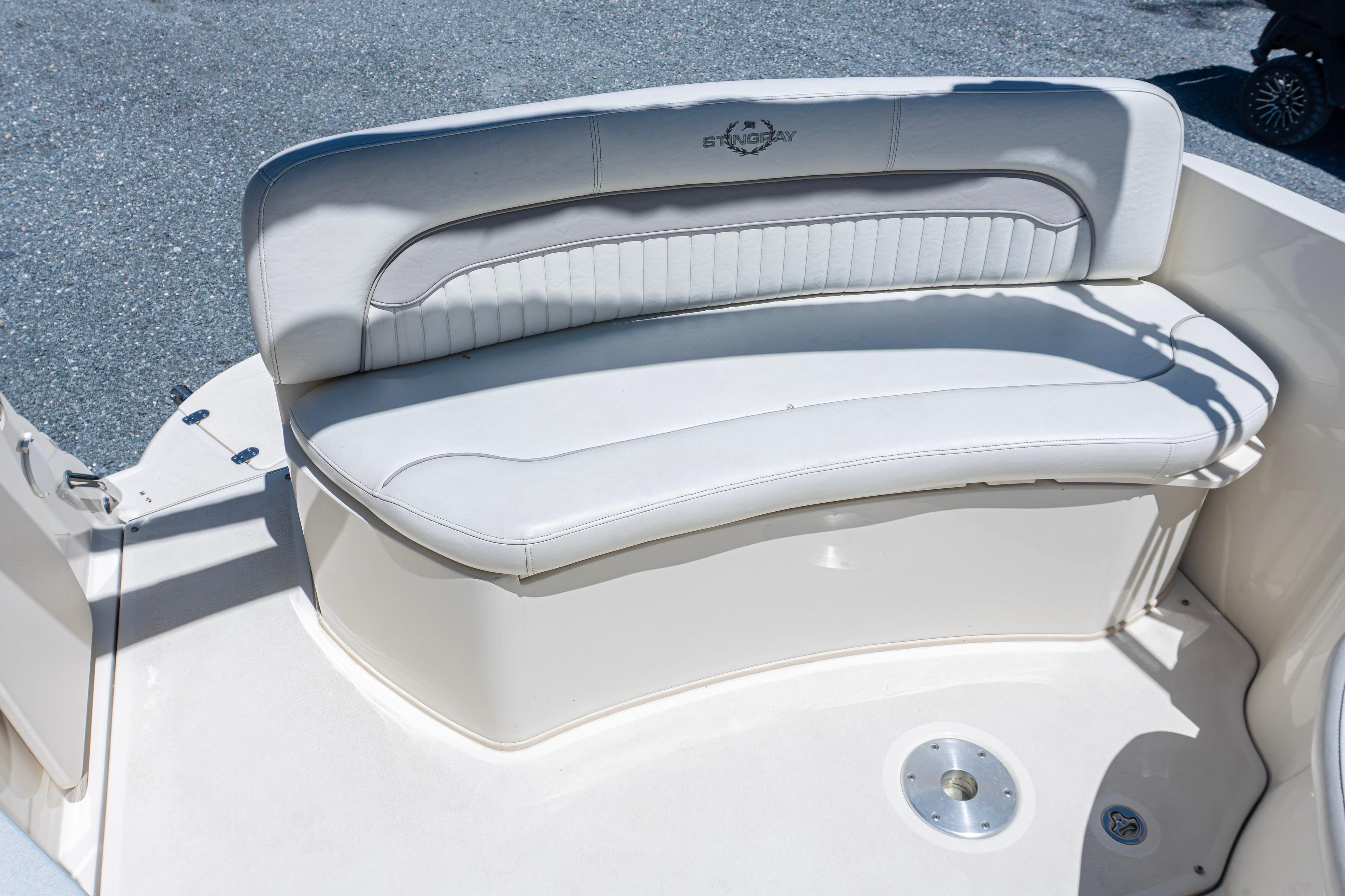 2007 Stingray 250 CS boat with white cushioned seating on deck.