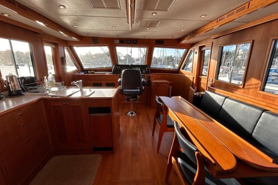 Luxurious interior of 2008 Grand Banks 59 Aleutian RP yacht with wood finish and seating area.