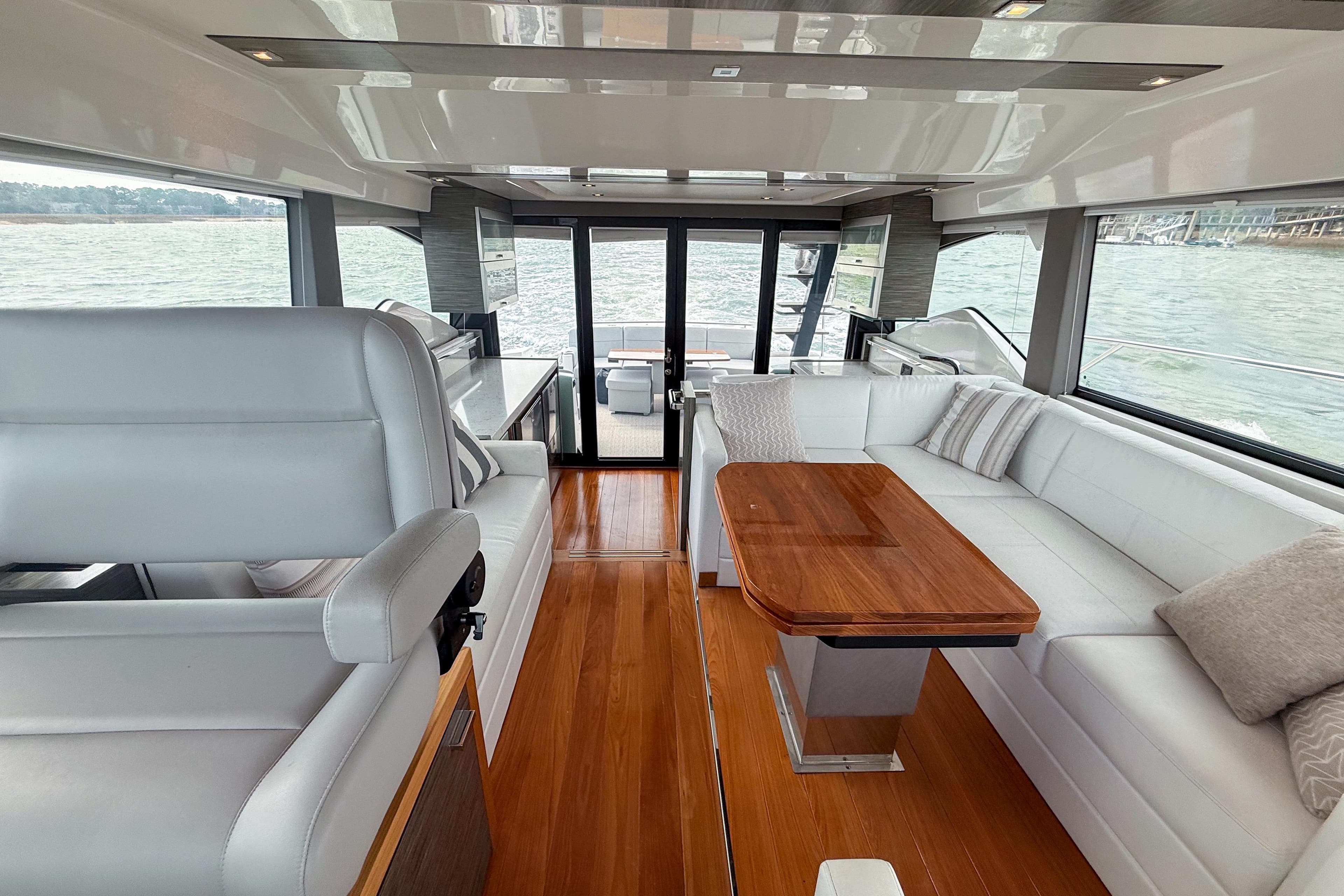 Luxurious interior of 2019 Tiara Yachts F53 Flybridge with elegant seating and wooden table.
