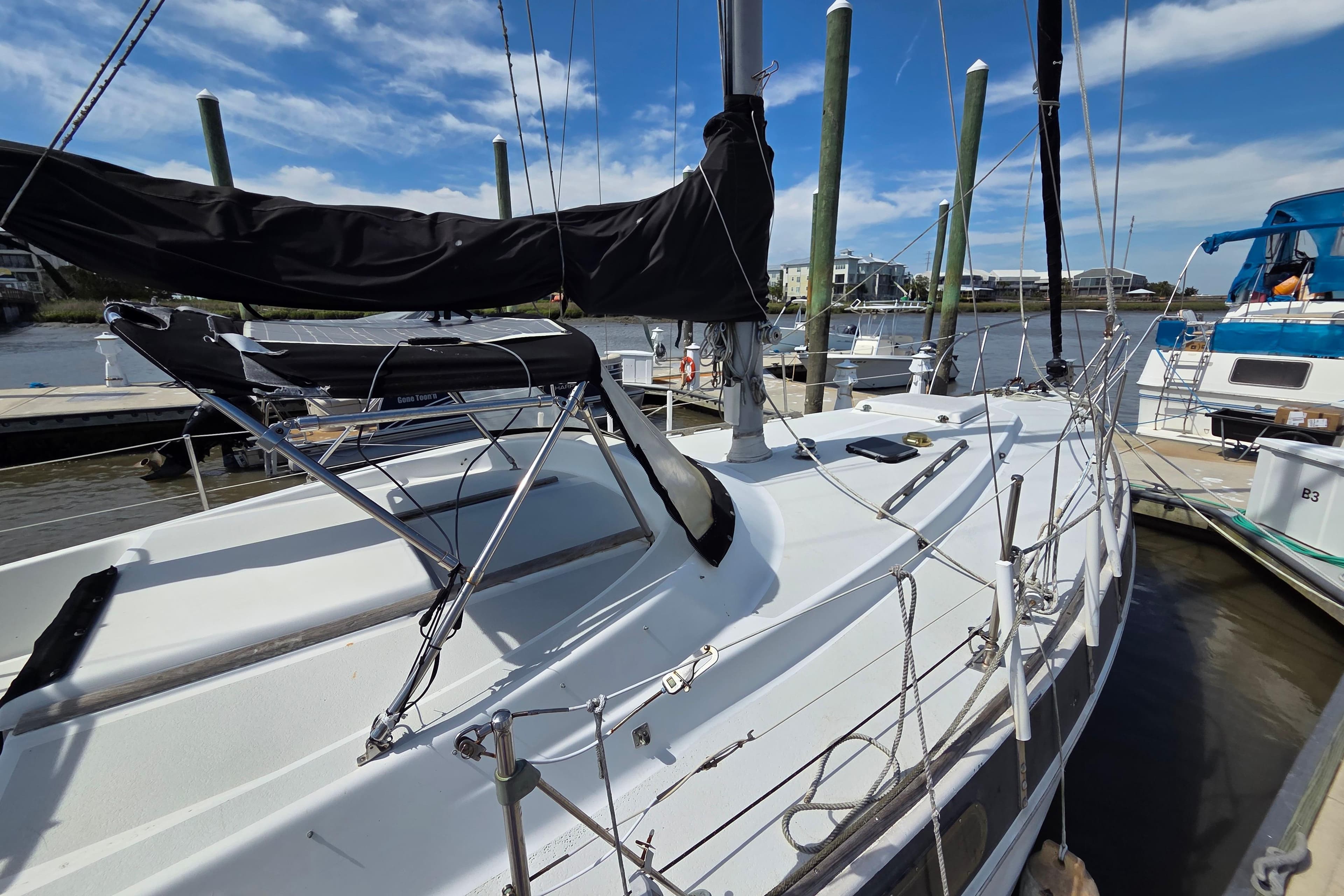1976 Morgan 33 Out Island sailboat docked at marina under clear blue sky.