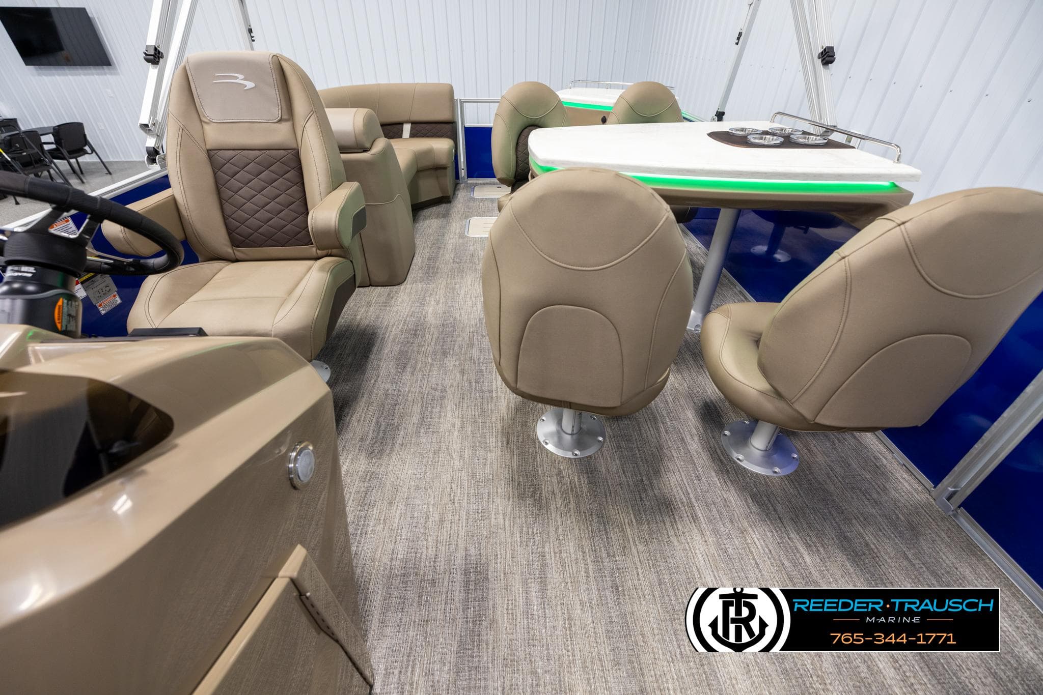 Interior of 2025 Bennington 23 SXPDSE pontoon boat with beige seating and table.