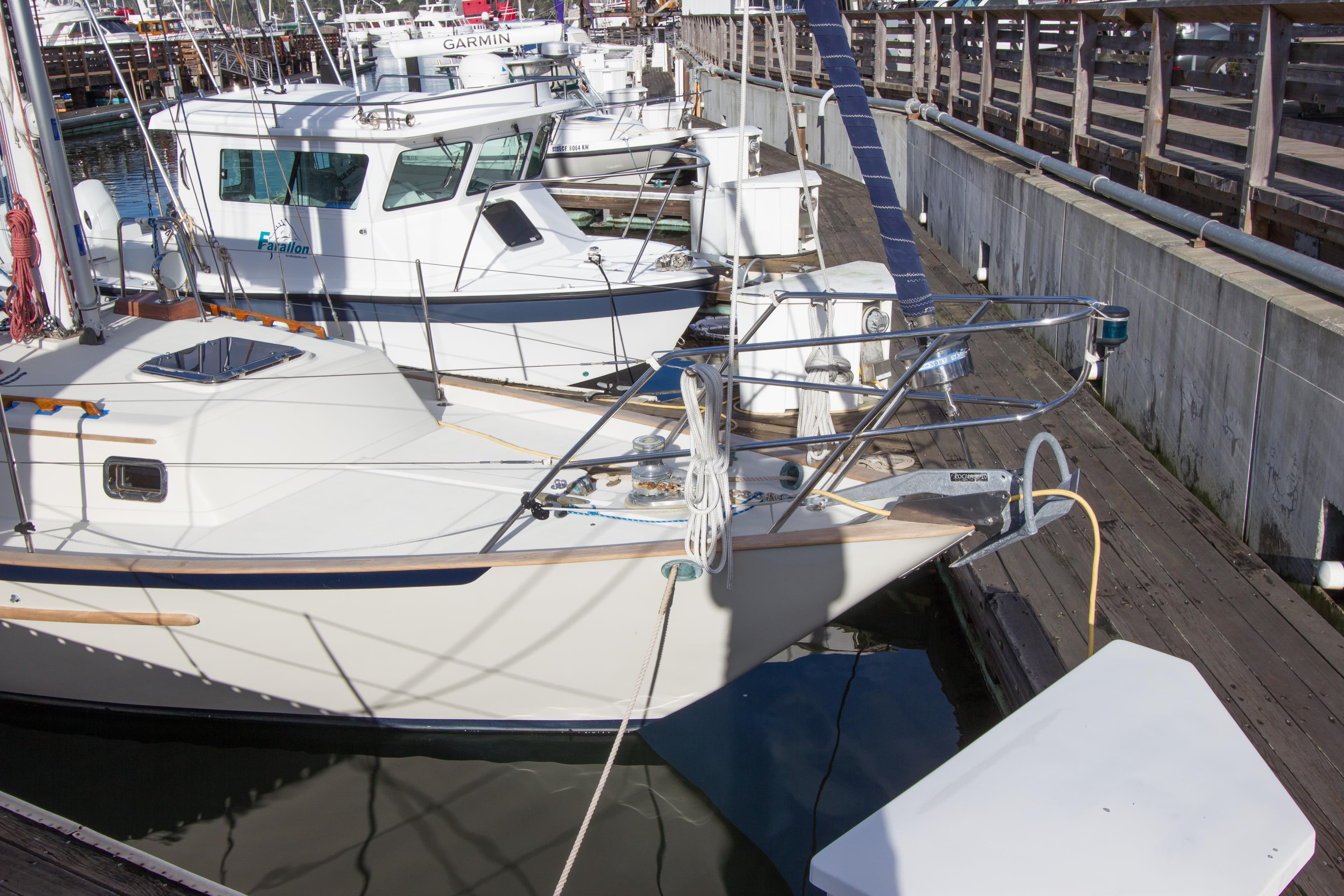1992 Pacific Seacraft 37 sloop docked at marina, surrounded by other boats.