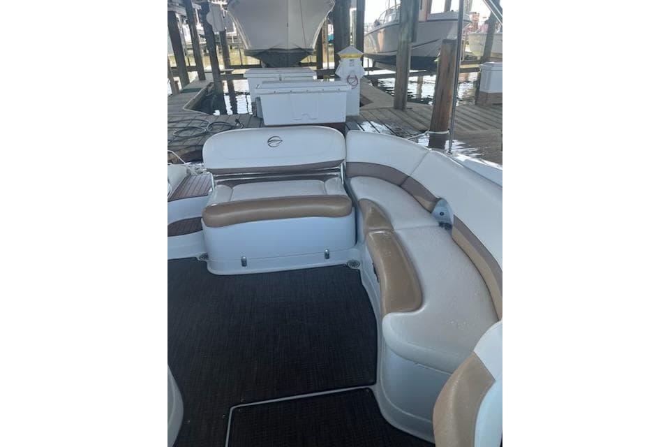2015 Crownline Eclipse E6 boat interior with white and tan seating under a dock.