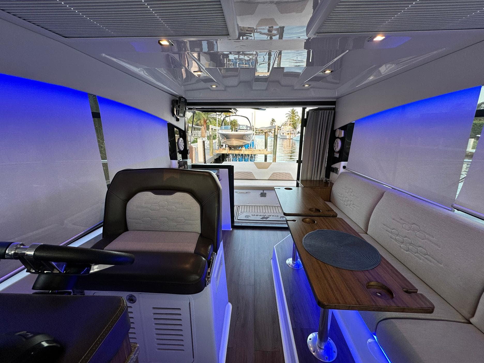 Interior of 2020 Four Winns Vista 355 Coupe with modern seating and ambient blue lighting.