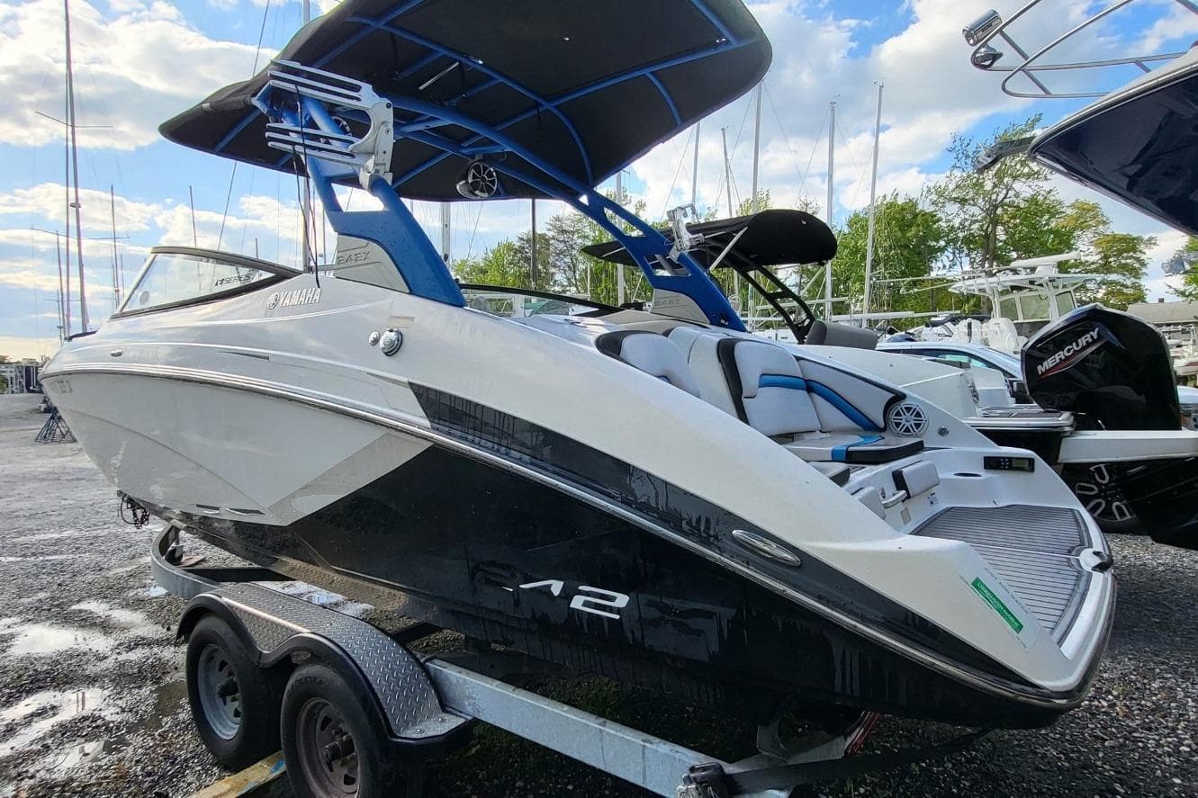 2018 Yamaha Boats 242X E-Series on trailer, featuring sleek design and spacious seating.