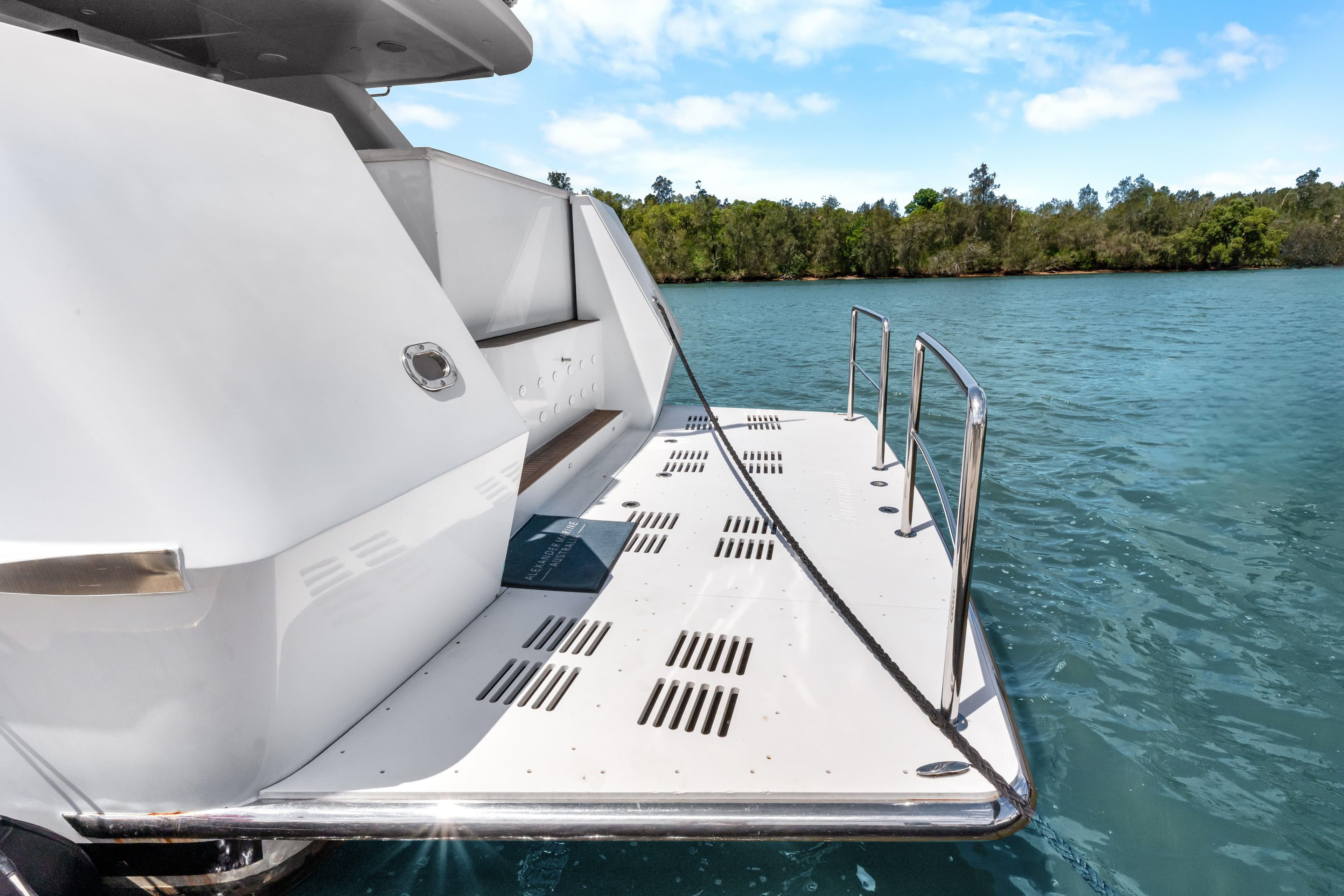 Sleek 2012 Custom 25m yacht deck with railing, docked on serene blue water.