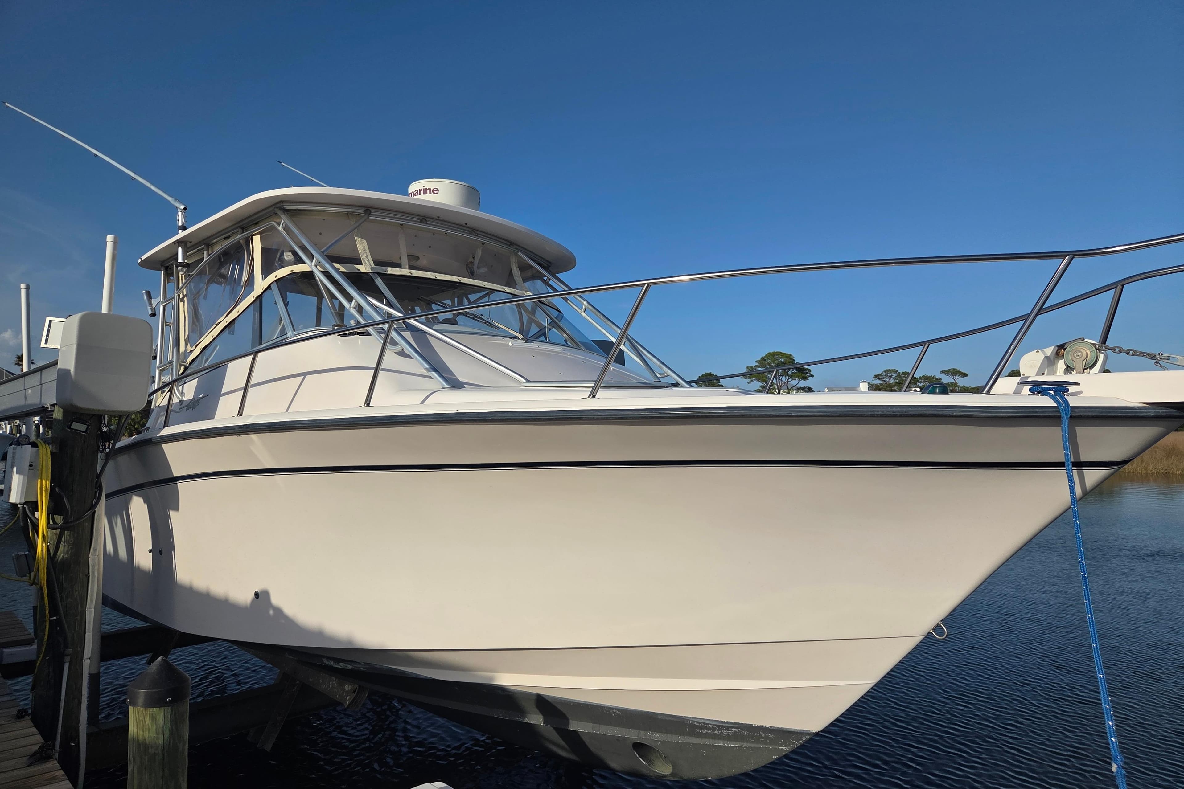 2004 Grady-White Express 330 boat docked on calm water under clear blue sky.